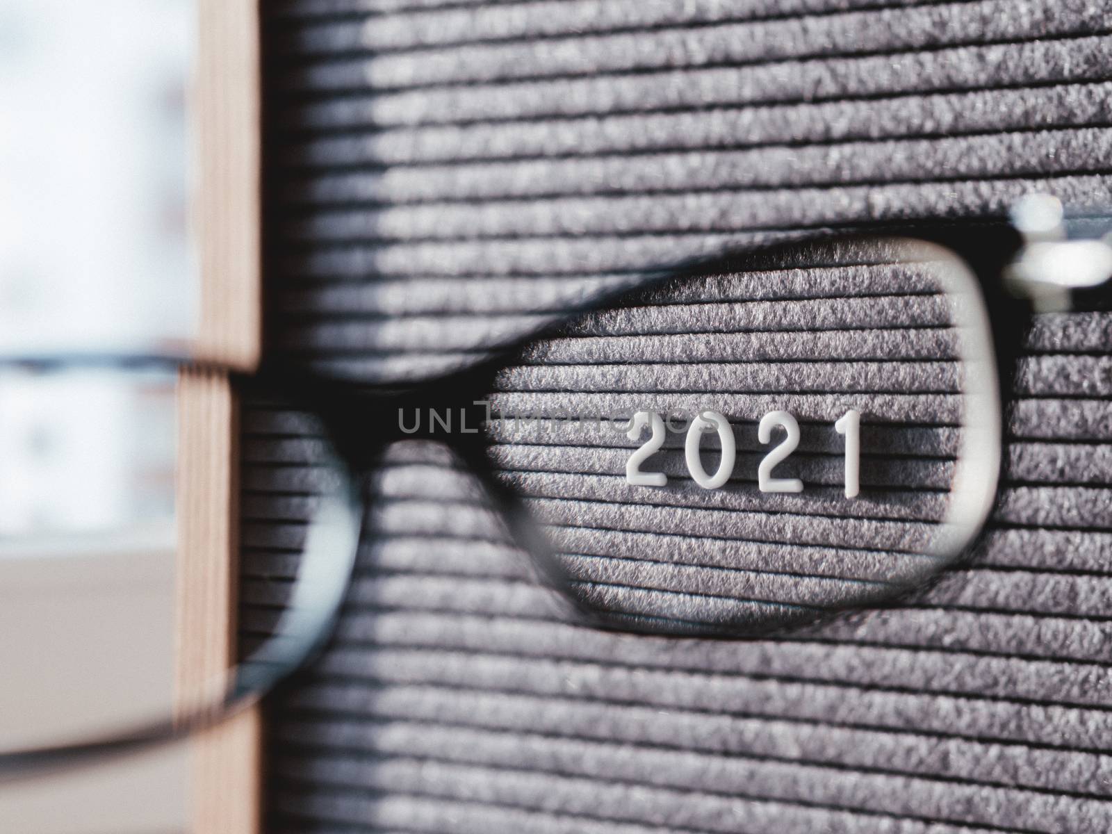 Letterboard with numbers 2021 through eyeglasses. Flat lay concept of 2021 year results. 2021 review. Social, political or economical issue. Closer look on problems and achievements.