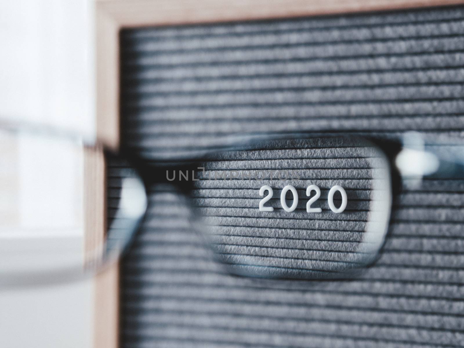 Top view on letterboard with numbers 2020 through eyeglasses. Flat lay concept of 2020 year results. 2020 review. Social, political or economical issue. Closer look on problems and achievements.