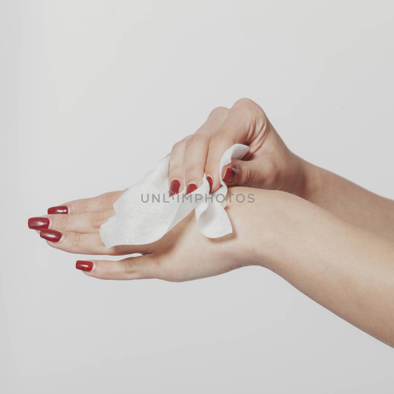 Young woman clean hands with wet wipes. Red nails