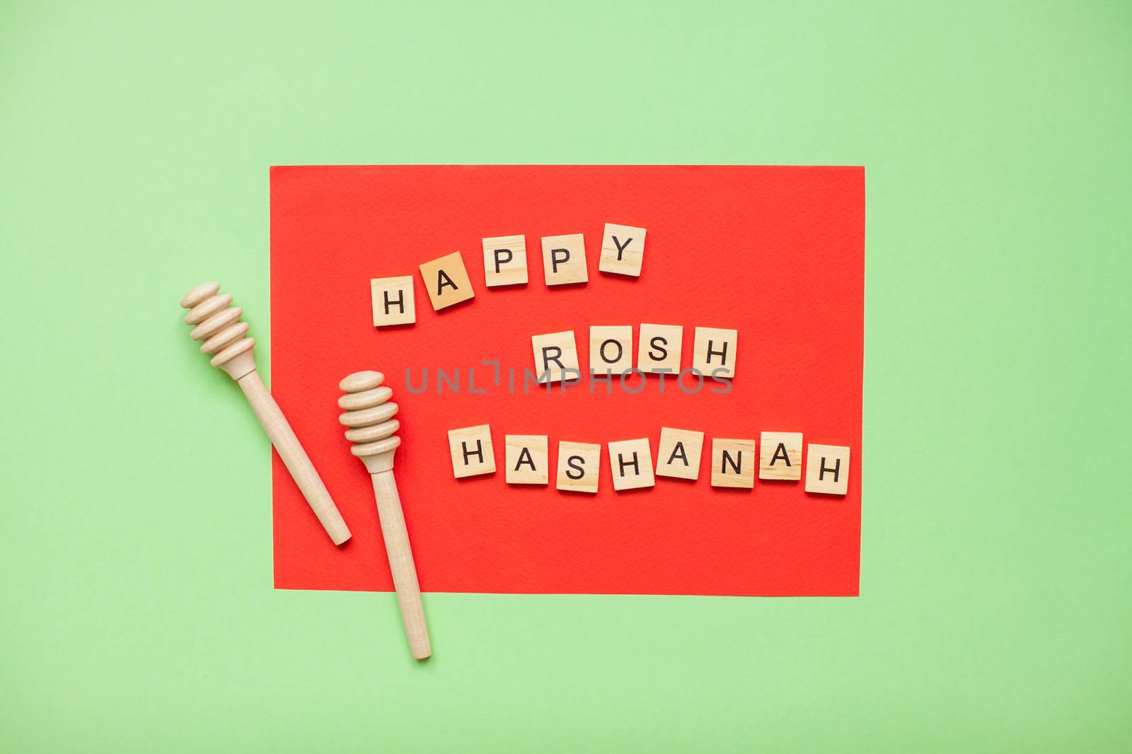 Words from wooden blocks 'happy rosh hashanah' and wooden spoons for honey by malyshkamju