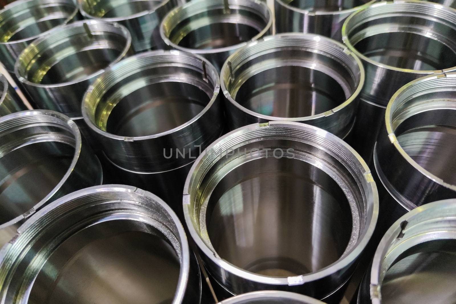 A close-up shot of shiny steel aerospace cnc turned tubes in a batch with selective focus and background blur.