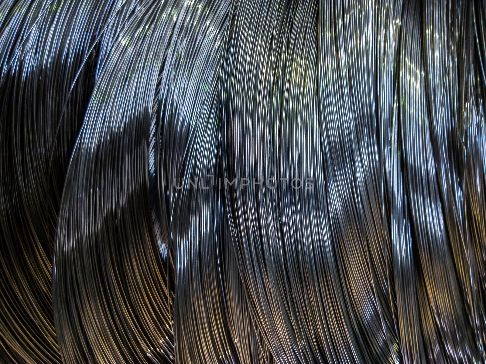 Closeup background of metal wire roll in silver color. Building material. Texture with selective focus and blur.