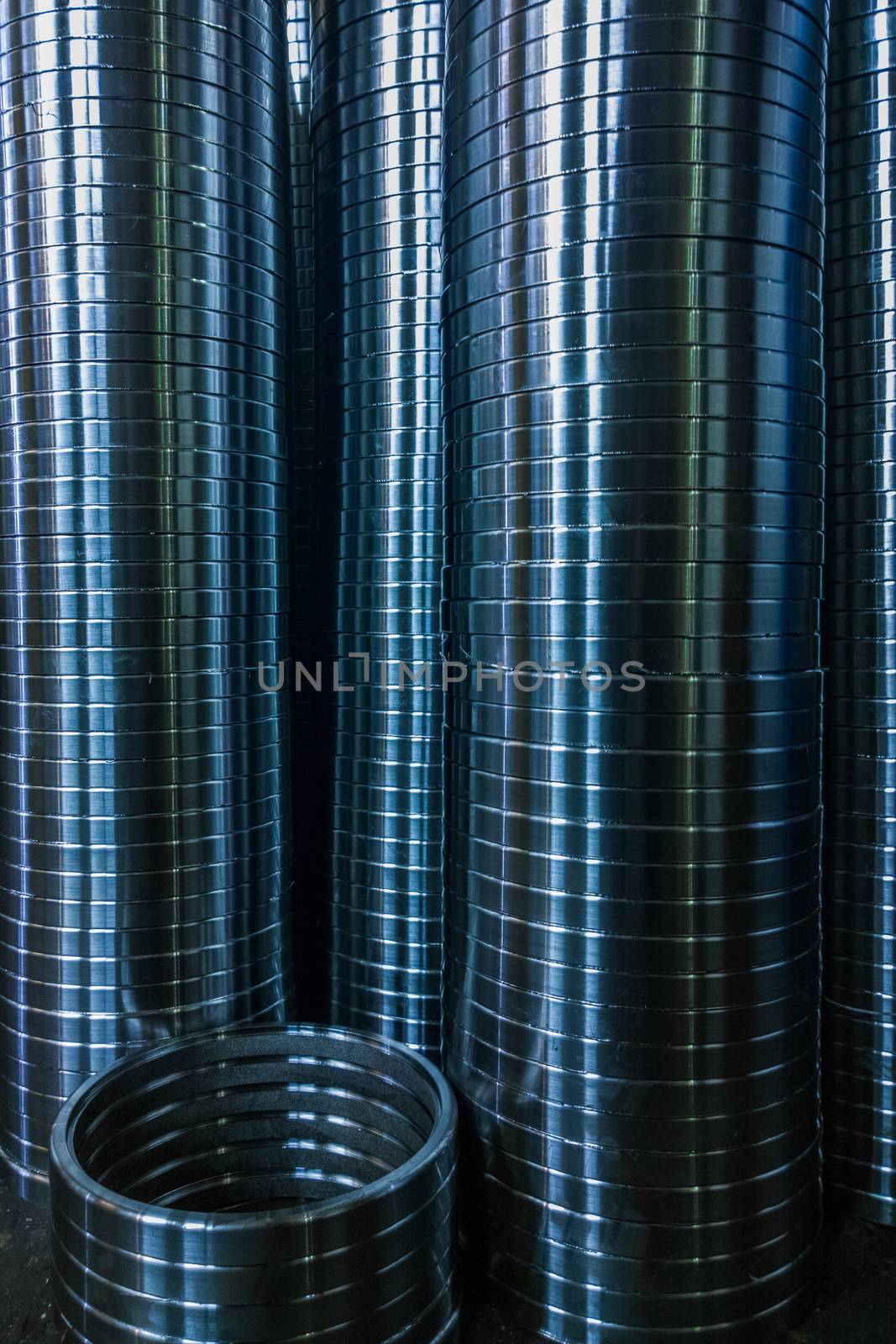 industrial manufacturing background of columns of shiny metal rings after cnc turning operation. Selective focus technique.