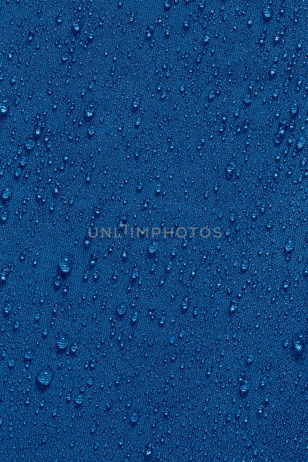 classic blue color waterproof hydrophobic flat cloth closeup with water drops background.