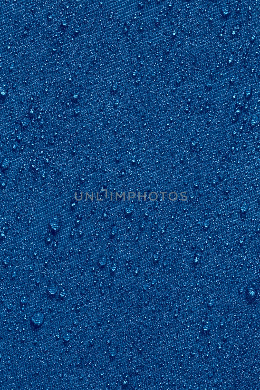 classic blue color waterproof hydrophobic flat cloth closeup with water drops background.