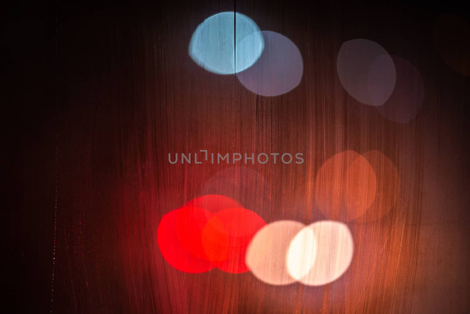 night street lights bokeh through wet glass, close-up with selective focus.