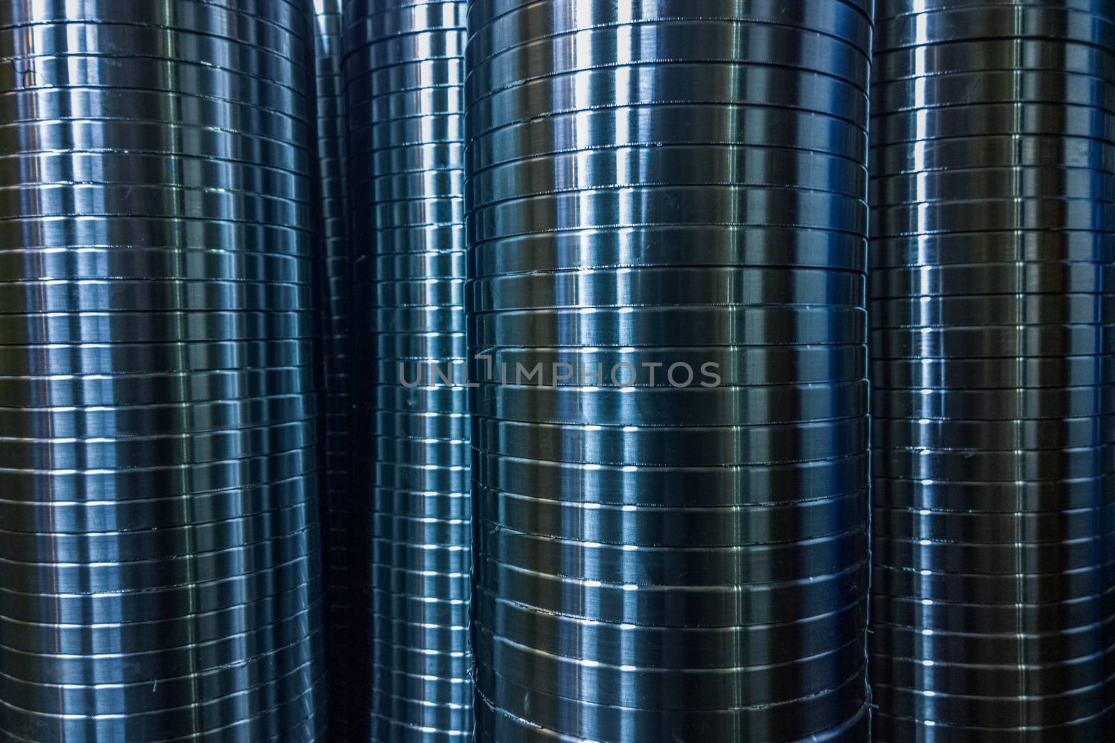 industrial manufacturing background of columns of shiny metal rings after cnc turning operation. Selective focus technique.