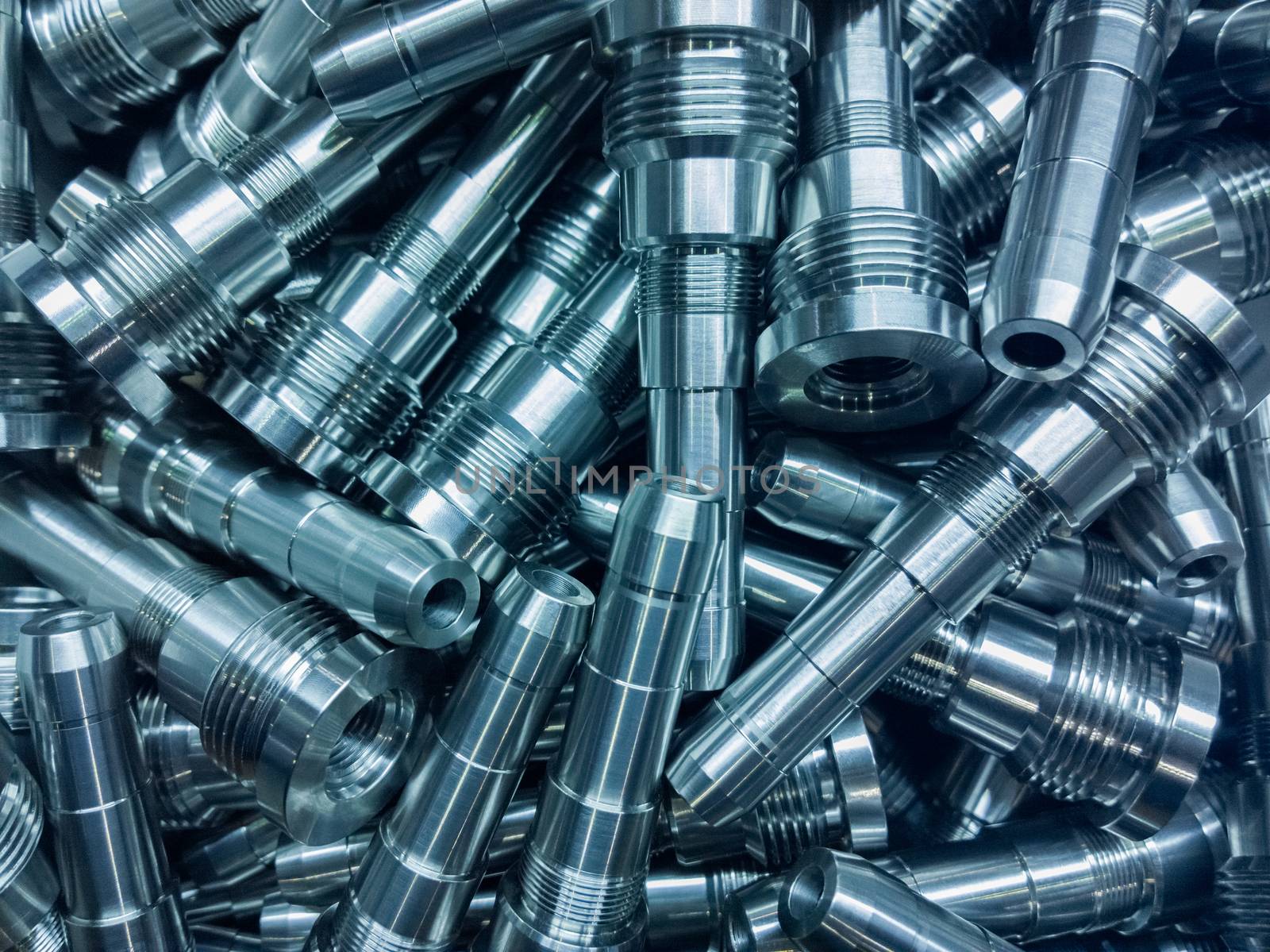 shiny steel parts background, a pile of long steel rods after modern fine cnc turning cut.