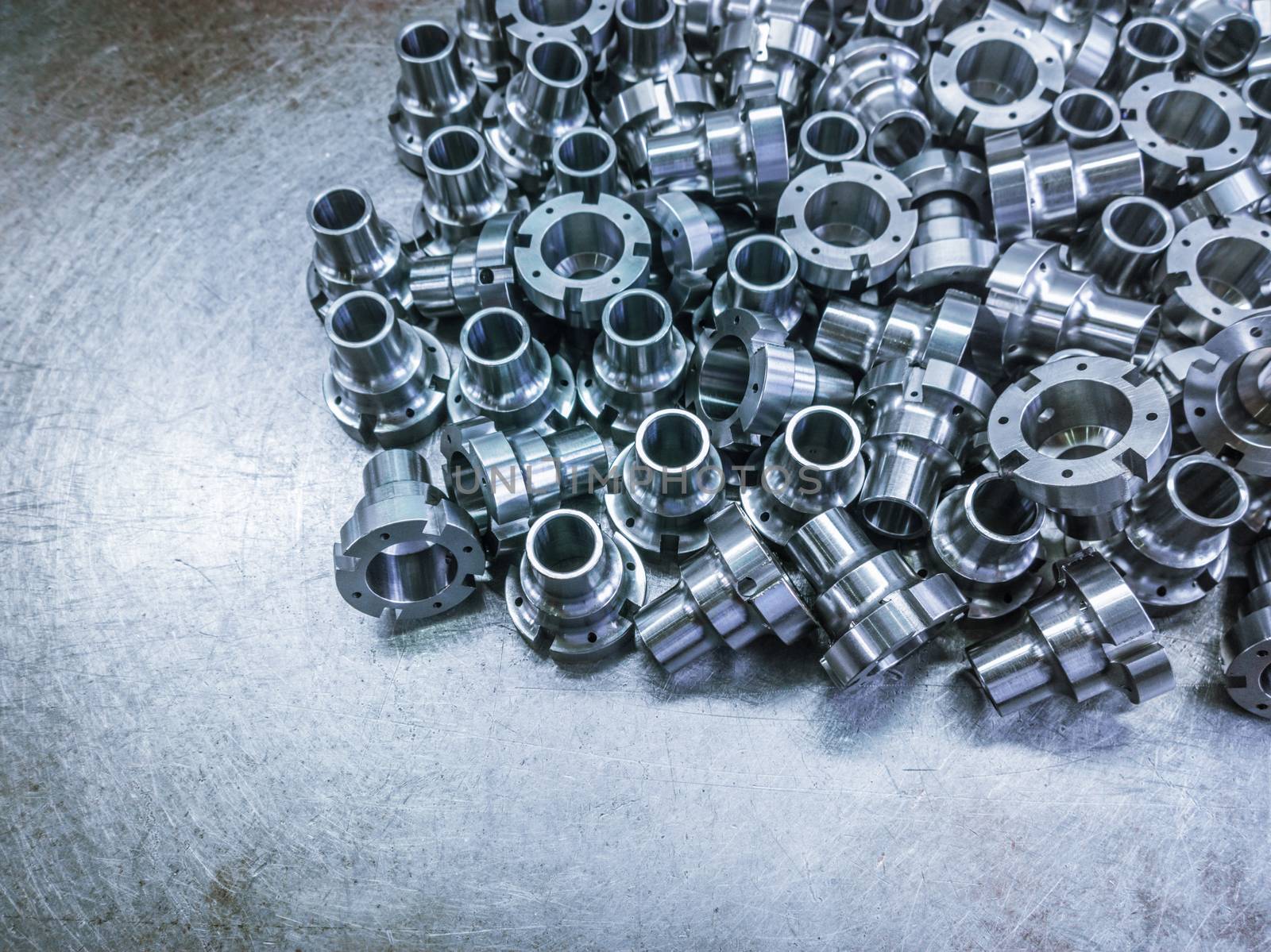 Shiny steel parts after cnc turning, drilling and machining on steel surface selective focus composition background.