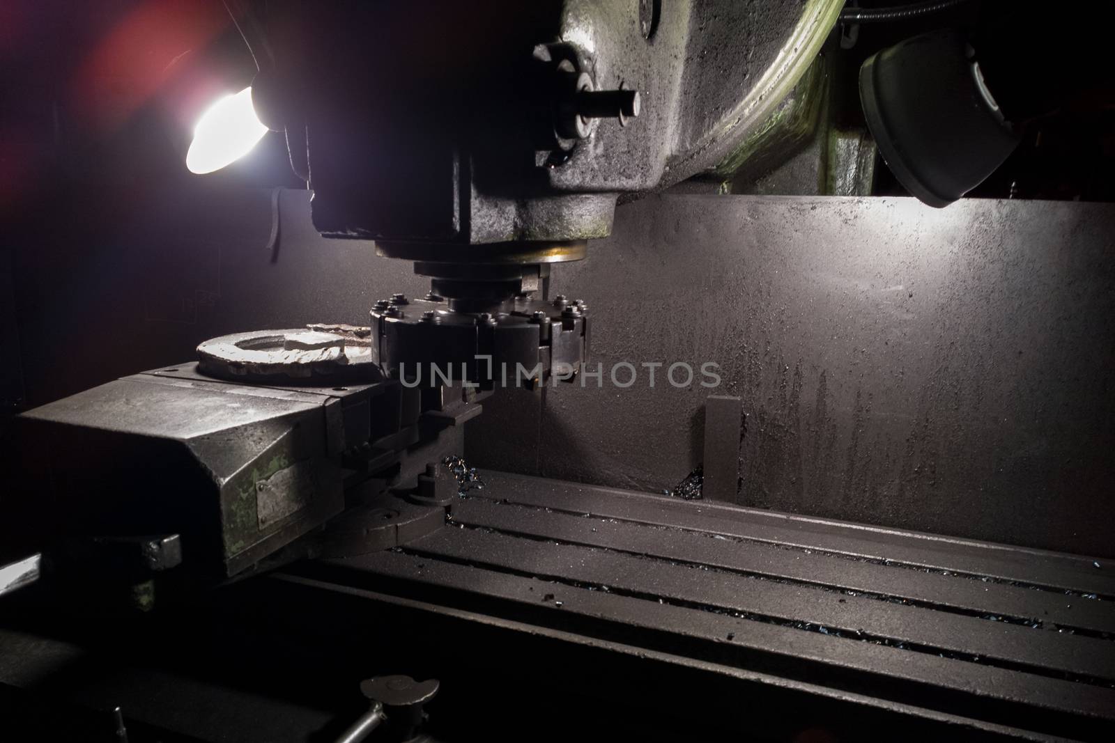 old manual milling machine in noir lighting style closeup with selective focus.