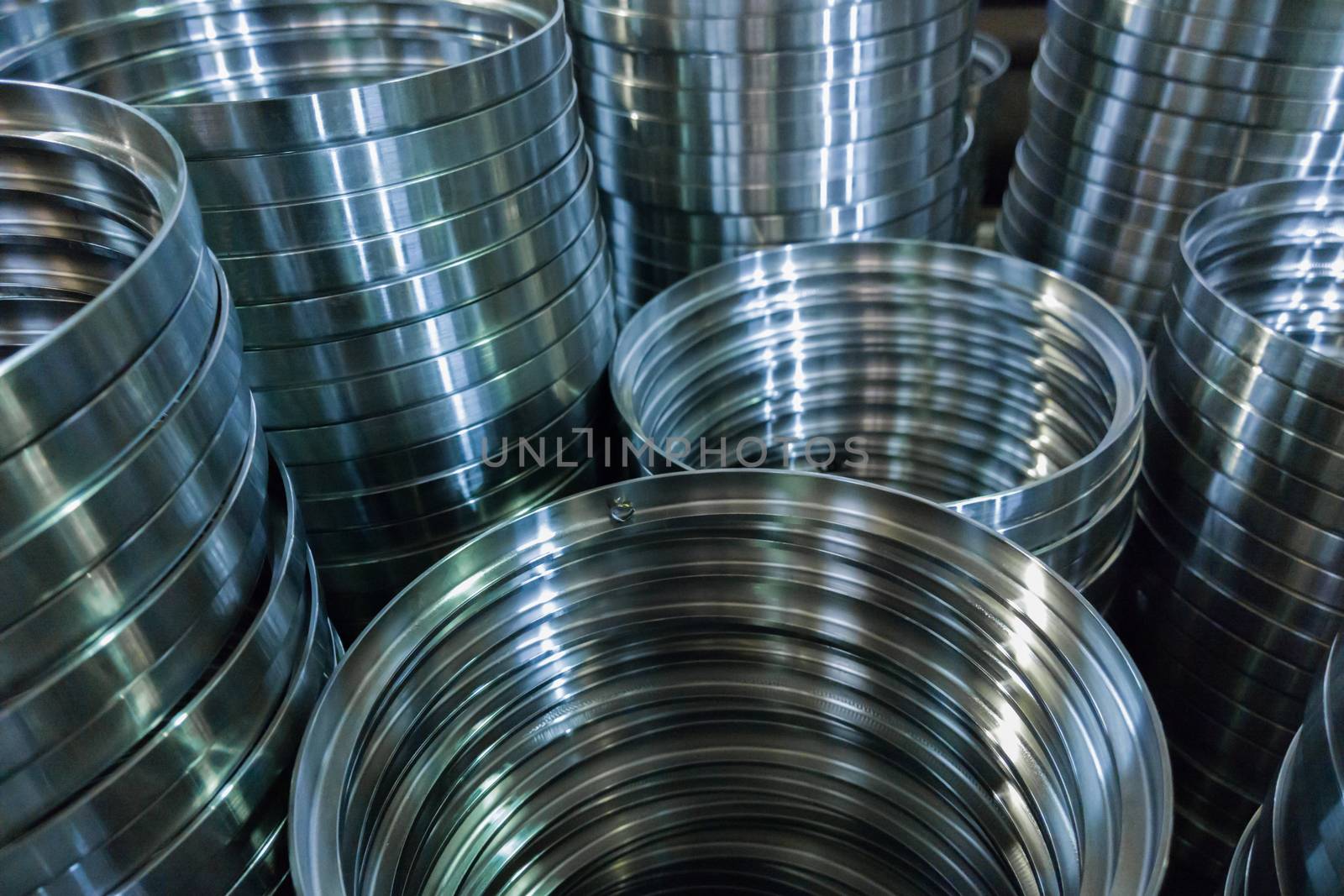 industrial manufacturing background of columns of shiny metal rings after cnc turning operation. Selective focus technique.