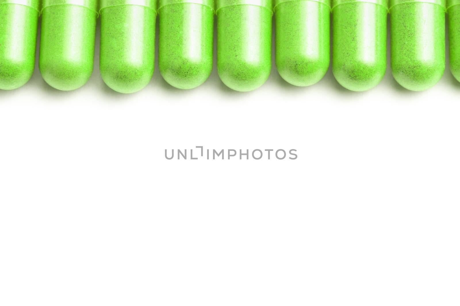 row of ufo green color organic capsules isolated on white background closeup with selective focus.