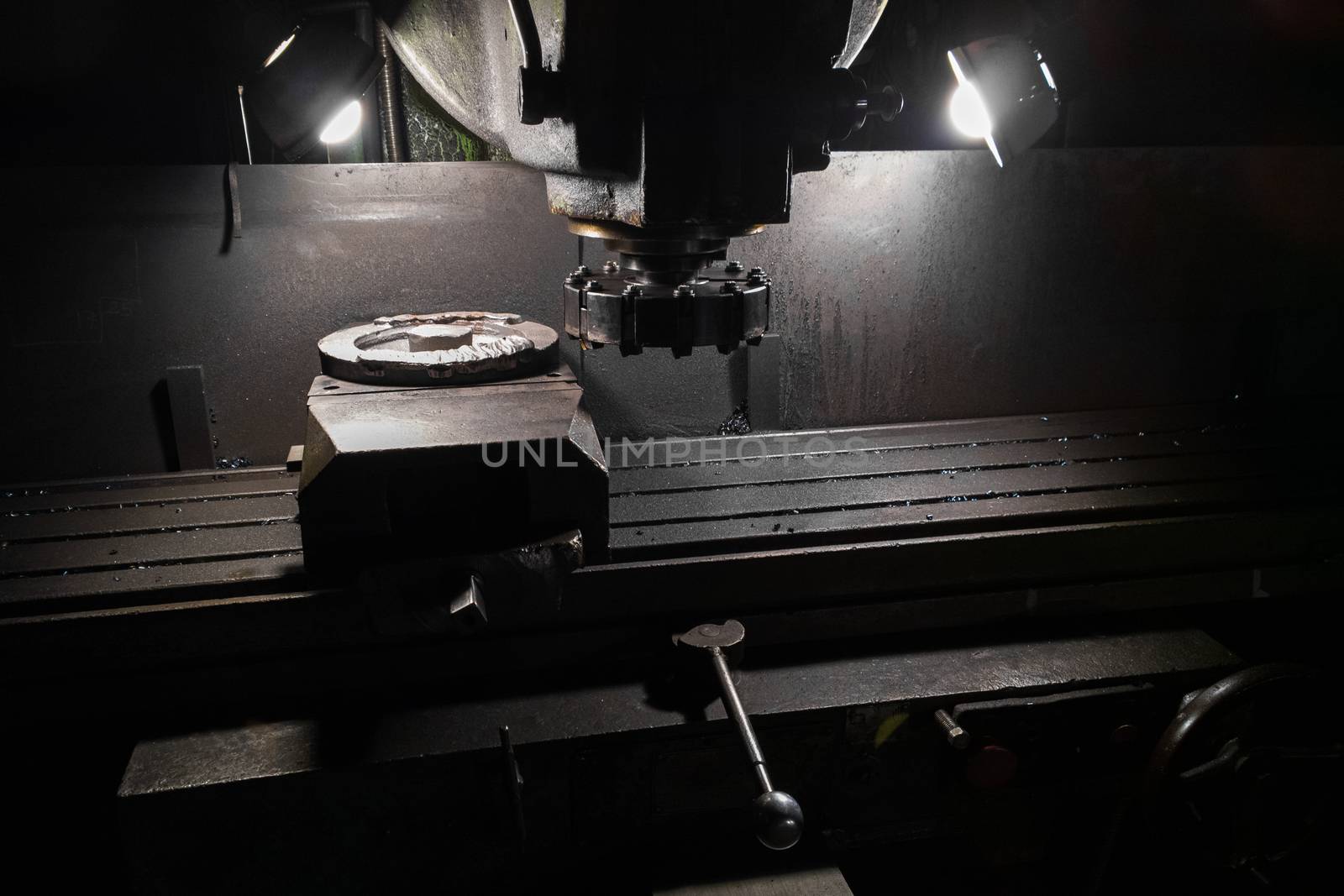 old manual milling machine in noir lighting style closeup with selective focus.