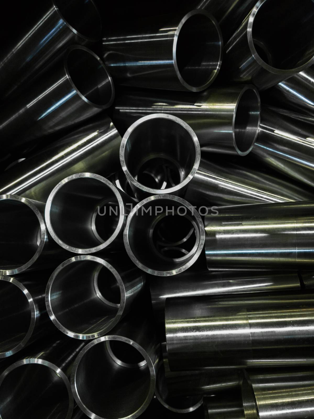dark industrial background with cnc machined shiny steel pipes - selective focus and lens blur tech by z1b