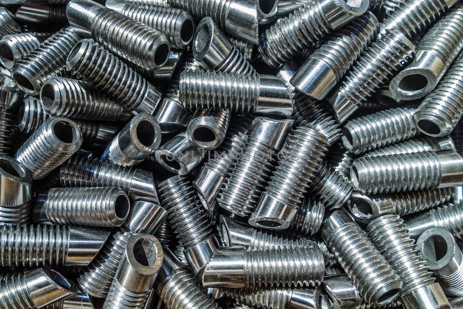 Shiiny metal car parts background with selective focus under direct sunlight.