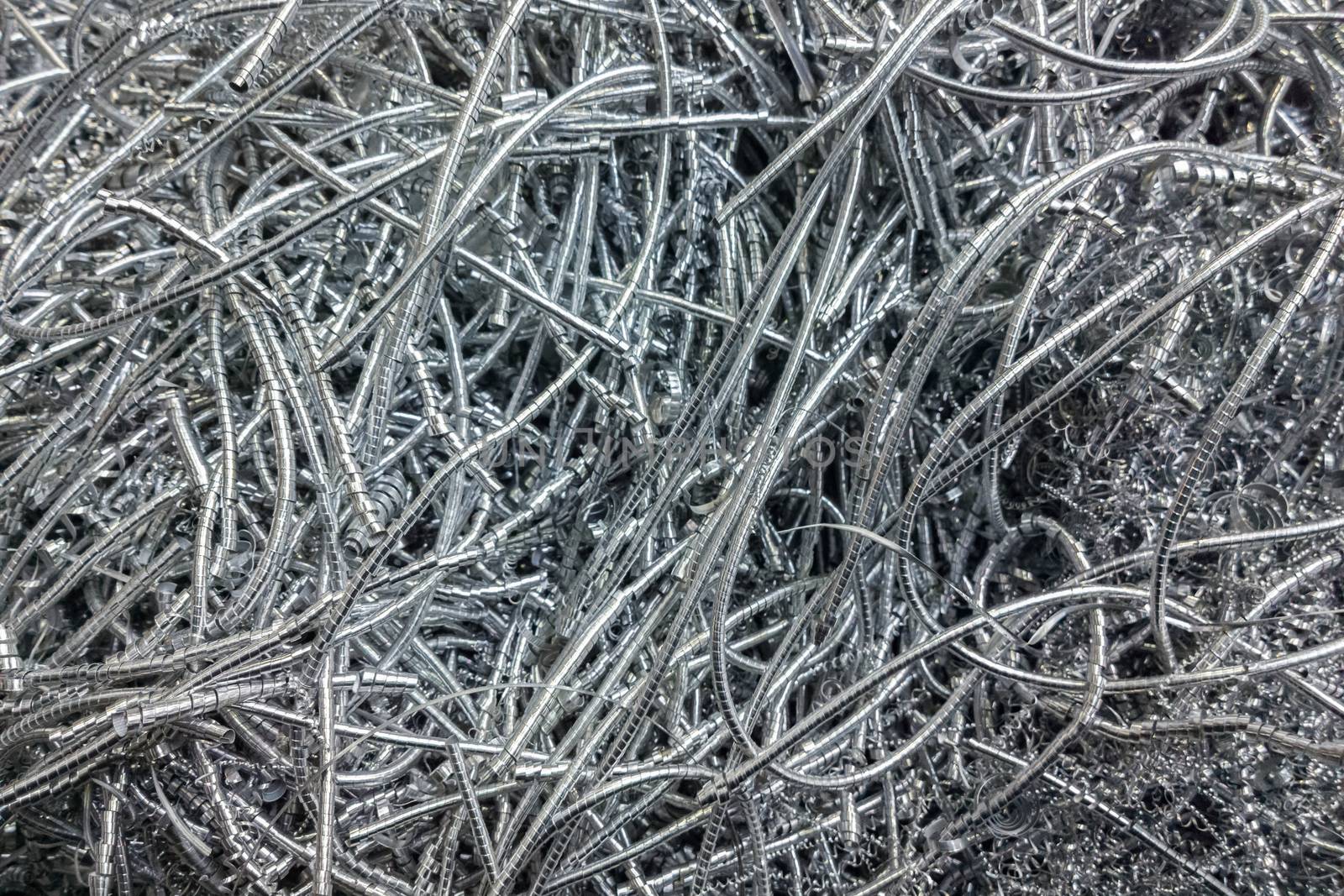 Long curly aluminium chips pattern background with selective focus.