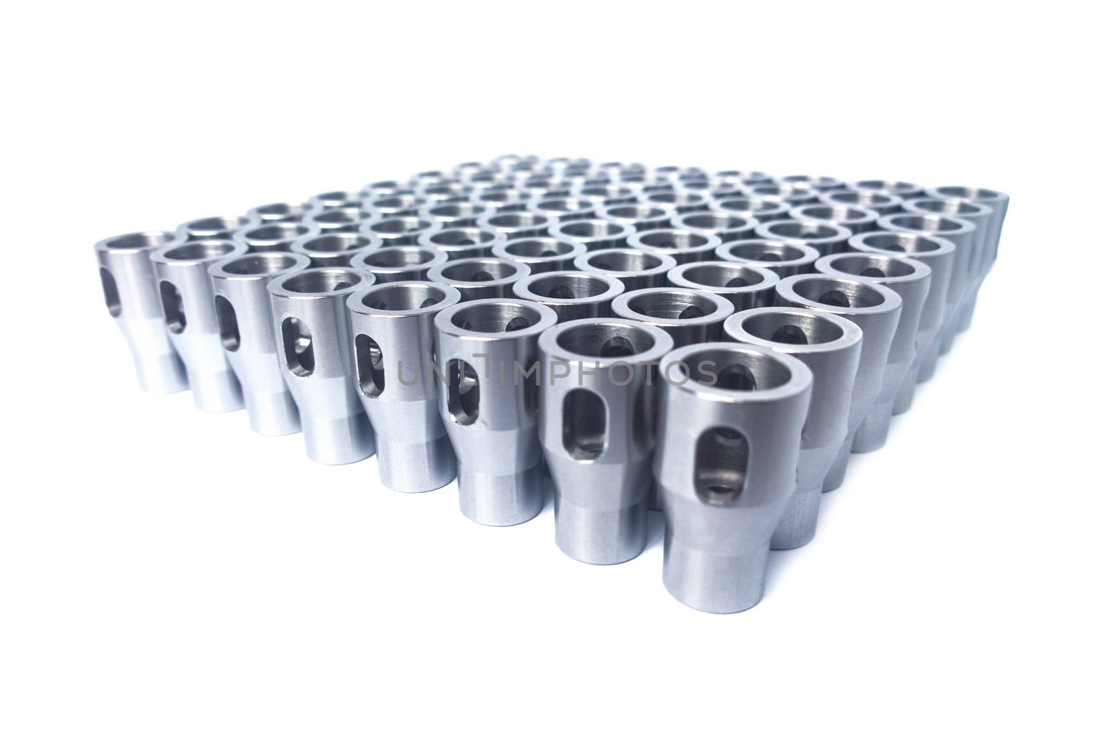 Shiny steel parts after cnc turning, drilling and machining isolated on white background with selective focus.