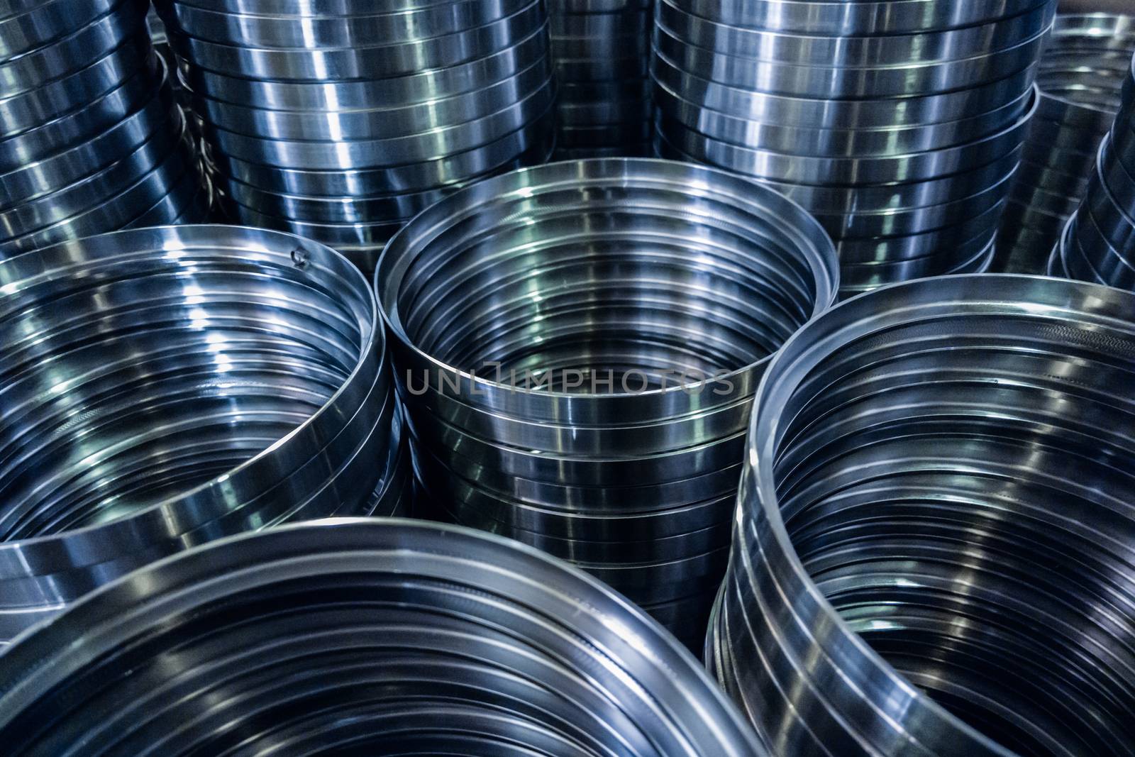 industrial manufacturing background of columns of shiny metal rings after cnc turning operation. Selective focus technique.