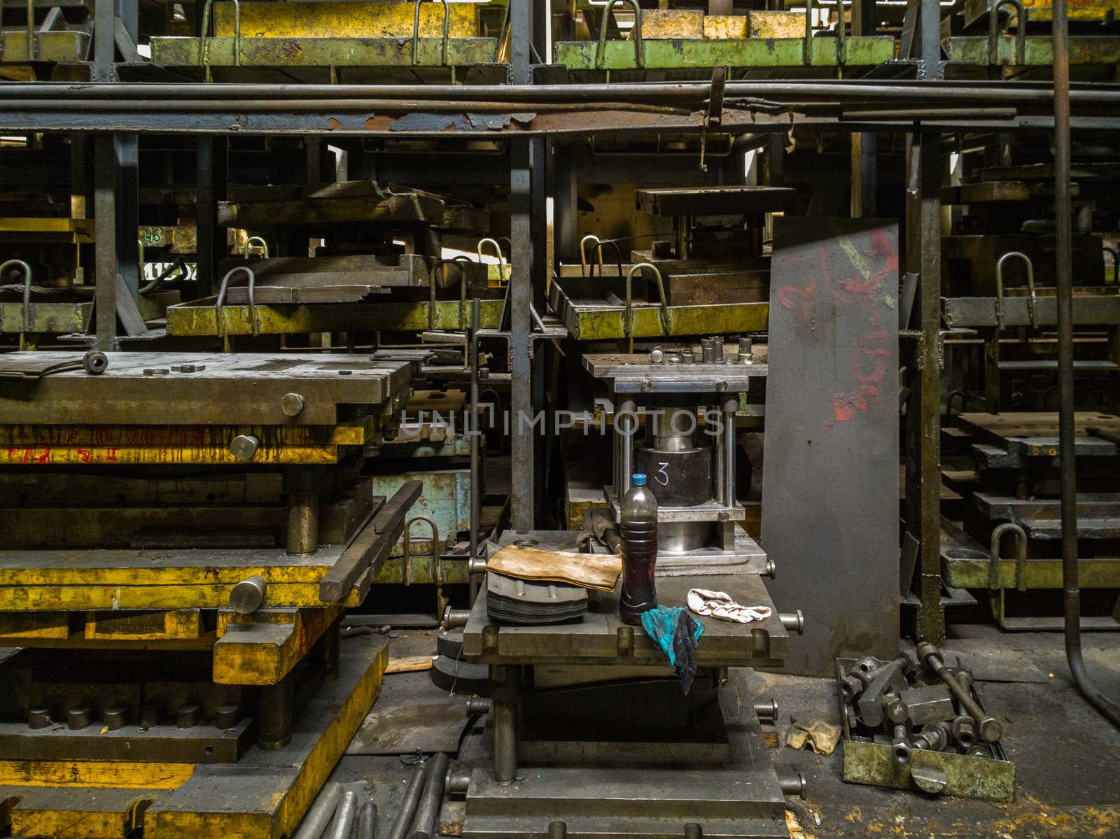 messy stamping shop with large stamps rack inside metalworking factory.