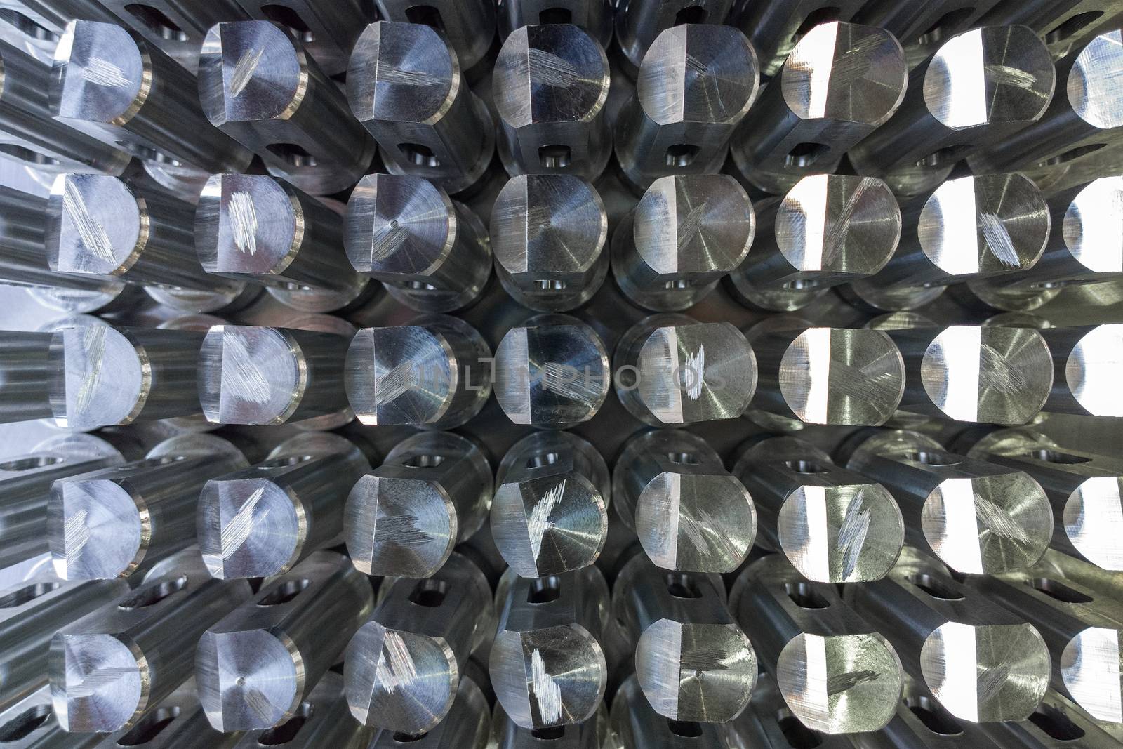Batch of shiny metal parts after cnc turning and milling top-down view with selective focus
