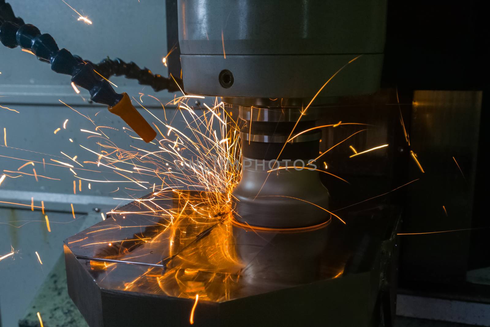 Heavy milling with sparks caused overheating due to wrong cutting feeds and speeds. Safety rules violation in manufacturing process. Selective focus technique in low light conditions.