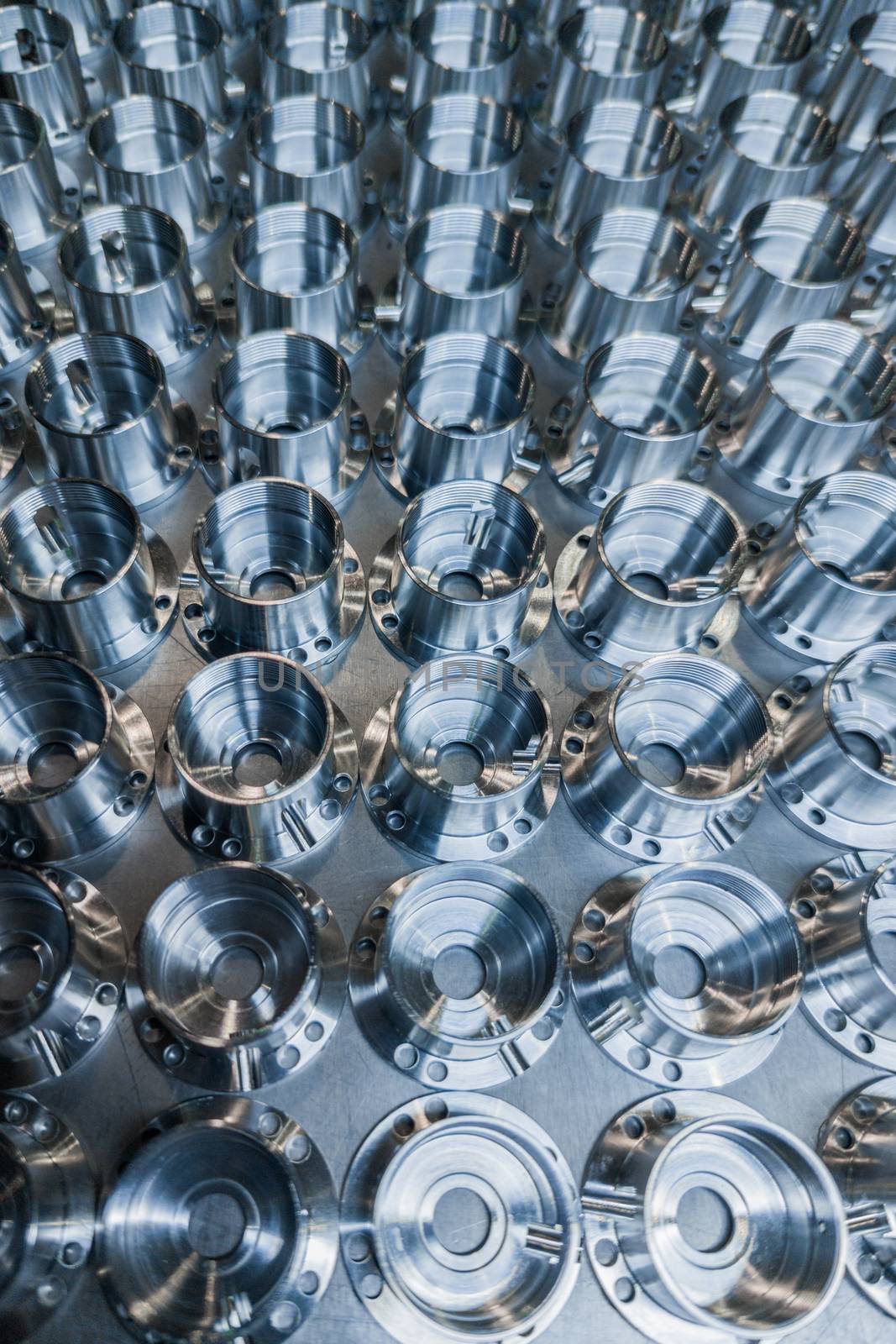 a batch of shiny metal cnc aerospace parts production - close-up with selective focus for industrial full frame background.