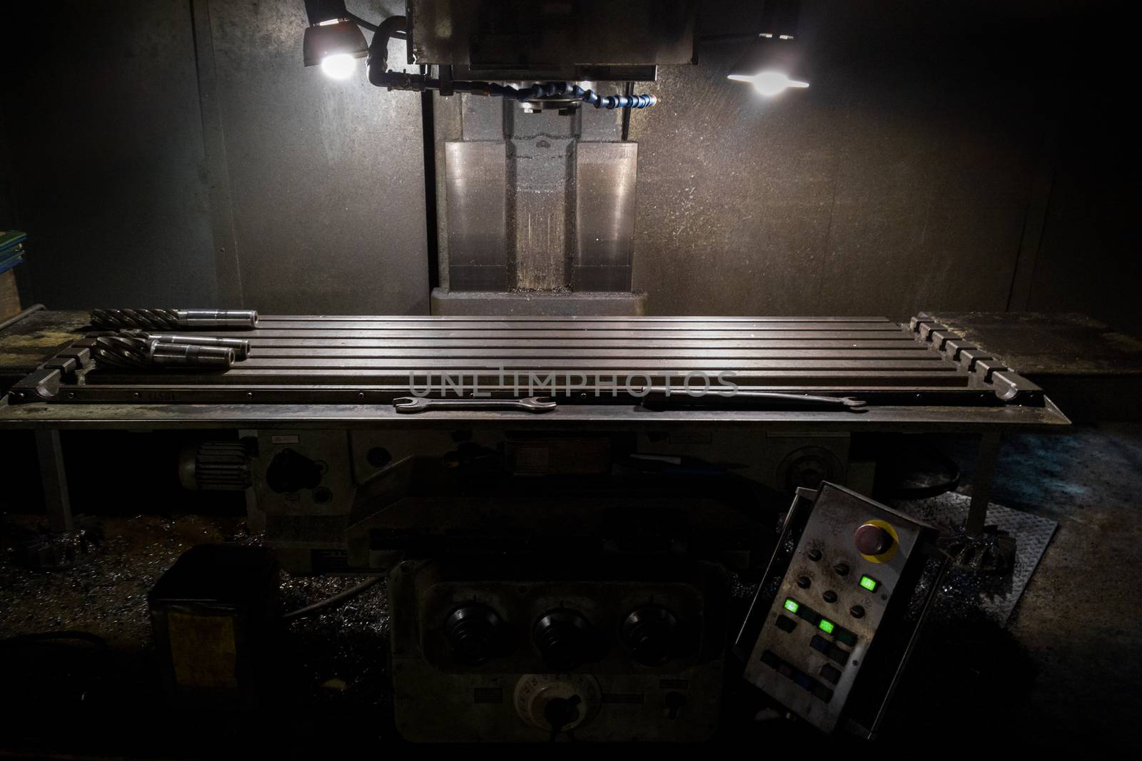 old manual milling machine in noir lighting style closeup with selective focus.