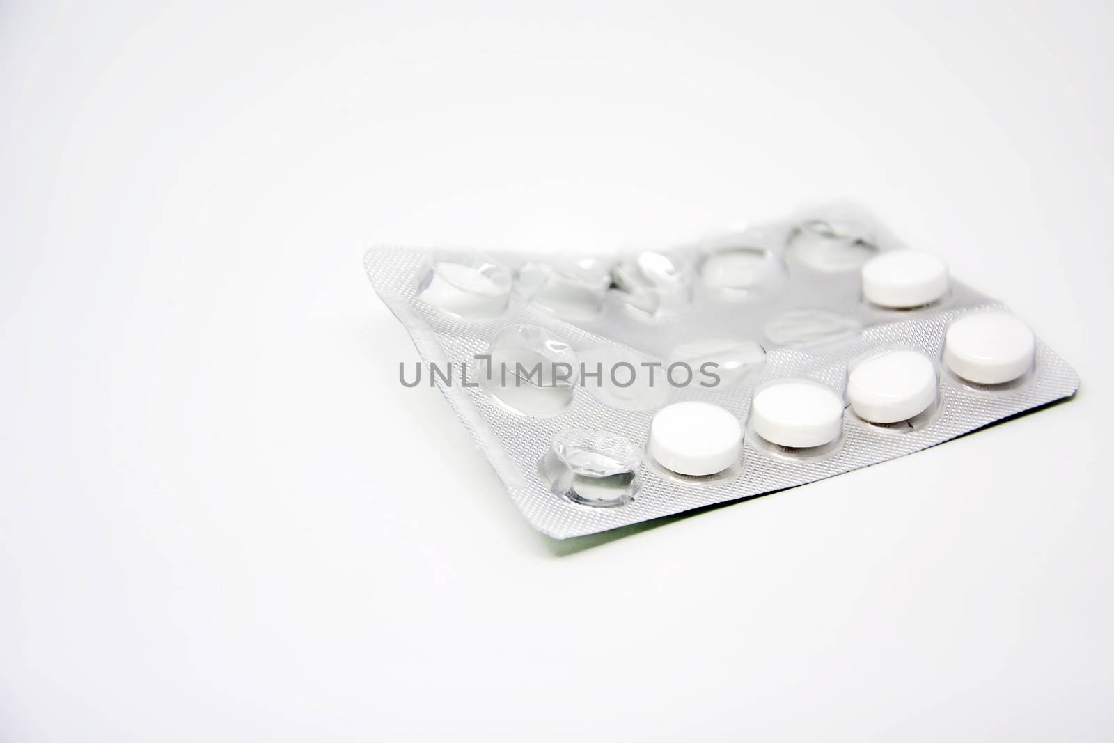 A used blister pack with some missing pills isolated on a white background. Medicine and pharmaceutical products.