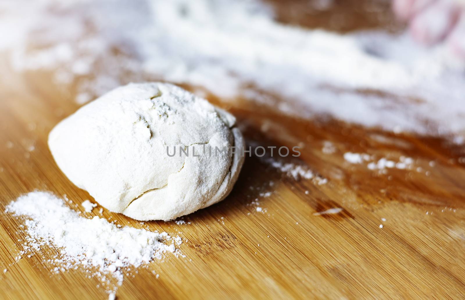 a fresh dough on a floured wooden board by rarrarorro