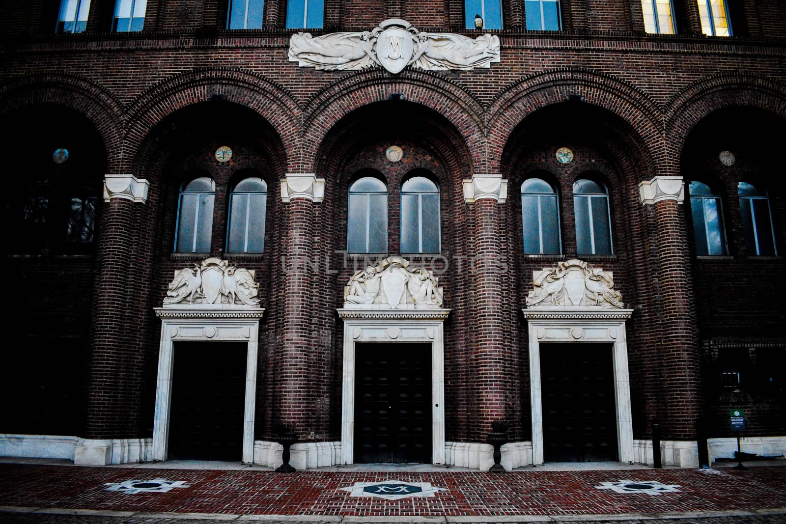 A Detailed Brick Building With Three Large Black Doors by bju12290