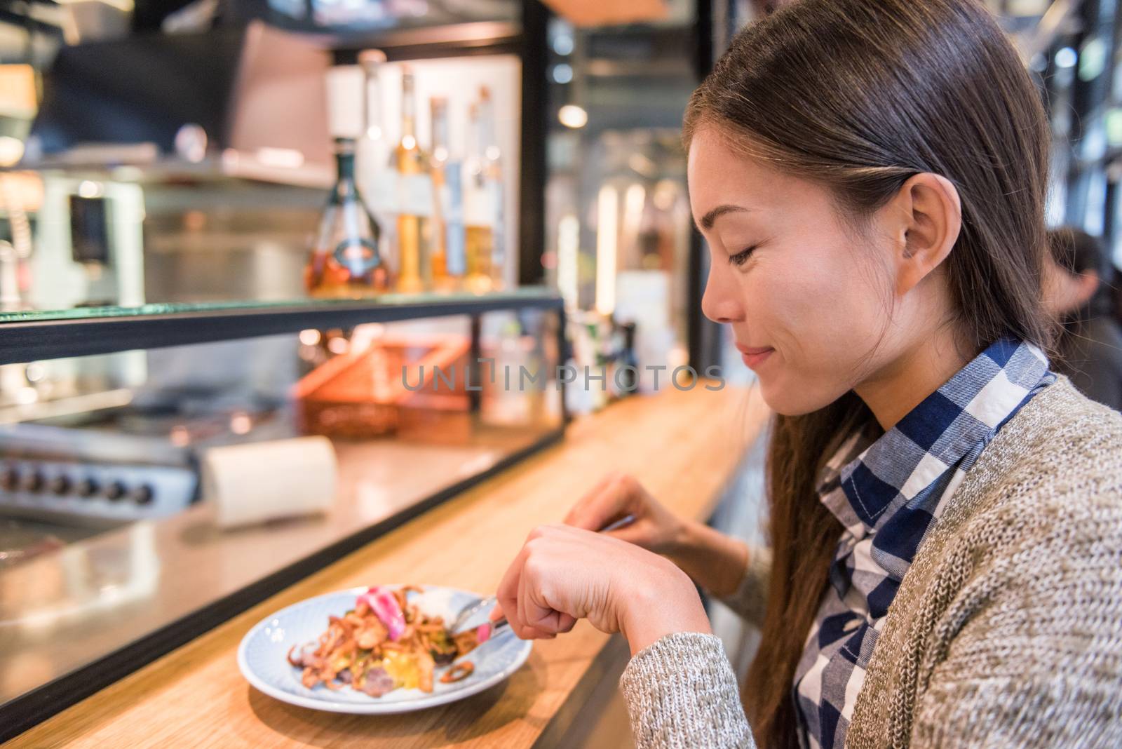 Woman eating at danish restaurant the traditional smorrebrod open sandwich at market stall counter. Happy Asian tourist trying typical meal from Denmark. Copenhagen city travel lifestyle. by Maridav