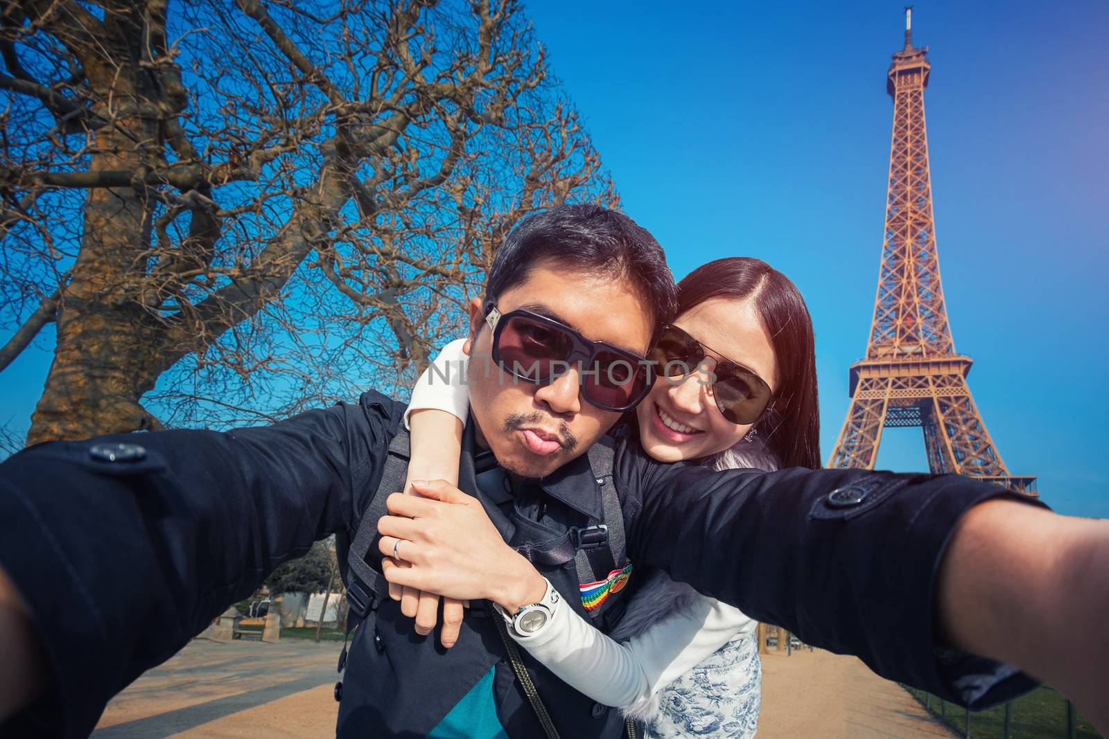 Young Couple Tourists selfie with mobile phone near the Eiffel tower in Paris, France