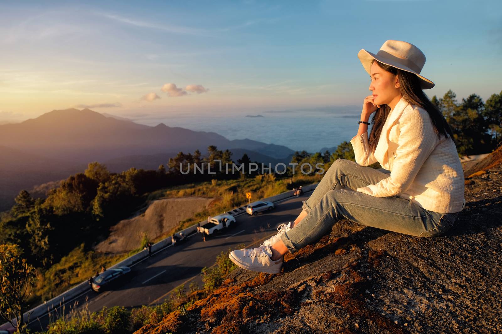 Happy woman siting on green grass meadow on top of mountain and  by Surasak