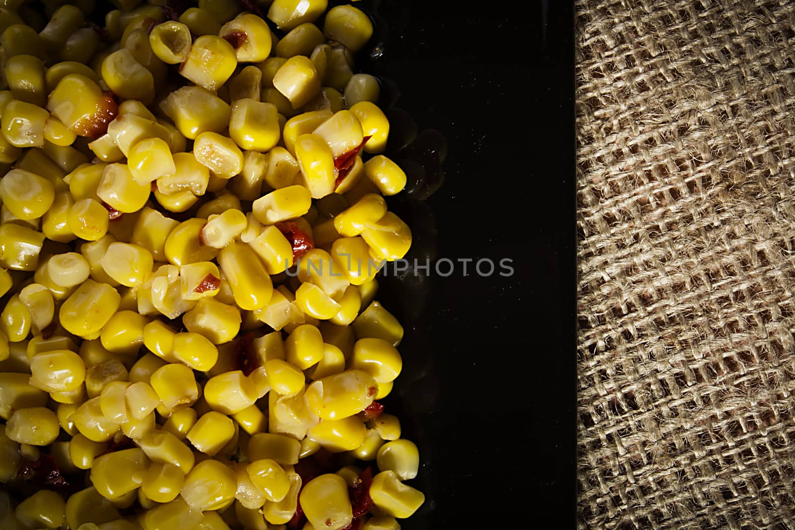 Tinned corn with pepper on a black plate