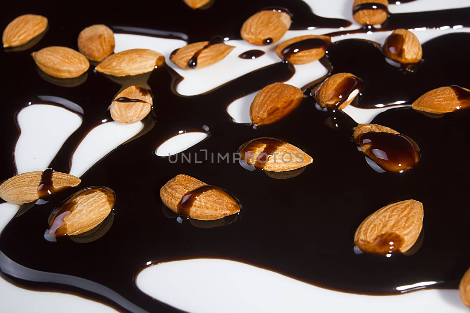 Almonds and melted chocolate on a white background