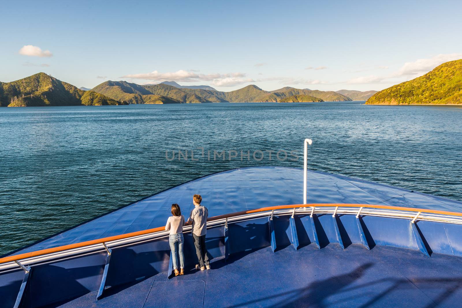 New Zealand cruise travel people enjoying nature view of ferry boat cruising in Marlborough sounds trip from Picton to Wellington, Cook strait crossing. Couple tourists watching sunset on deck. by Maridav