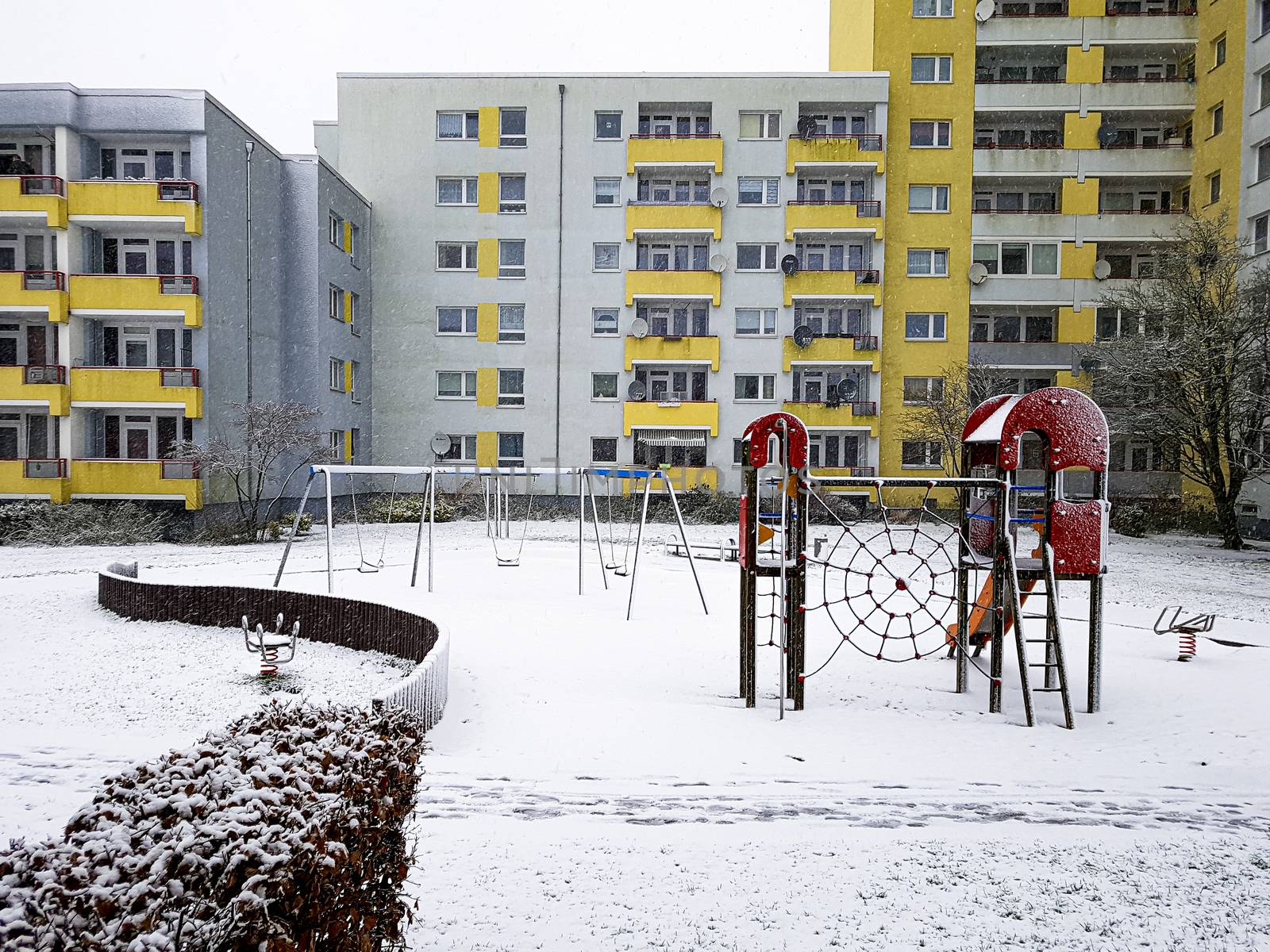 Playground with white snow in winter time in Leherheide, Bremerhaven. by Arkadij