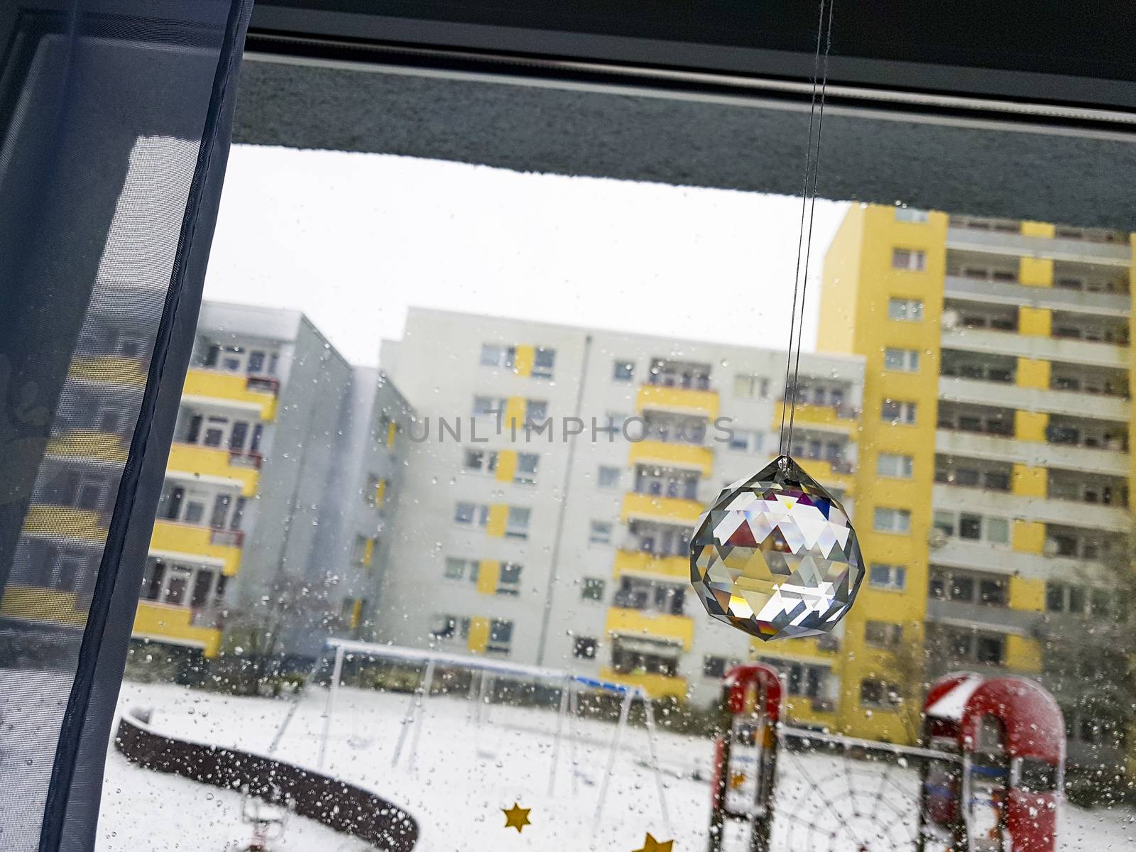 Winter decoration crystal ball on the window. Playground with snow in the background.