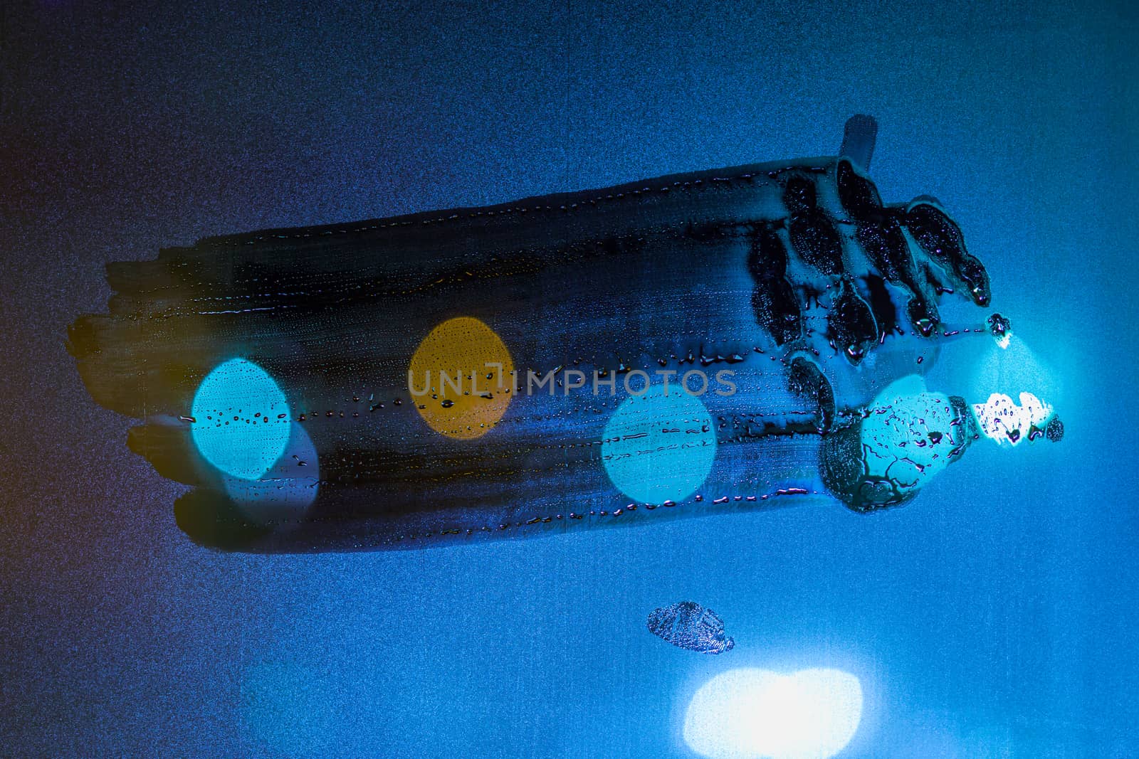 a night wet window glass wiped by hand - dark background and mockup.