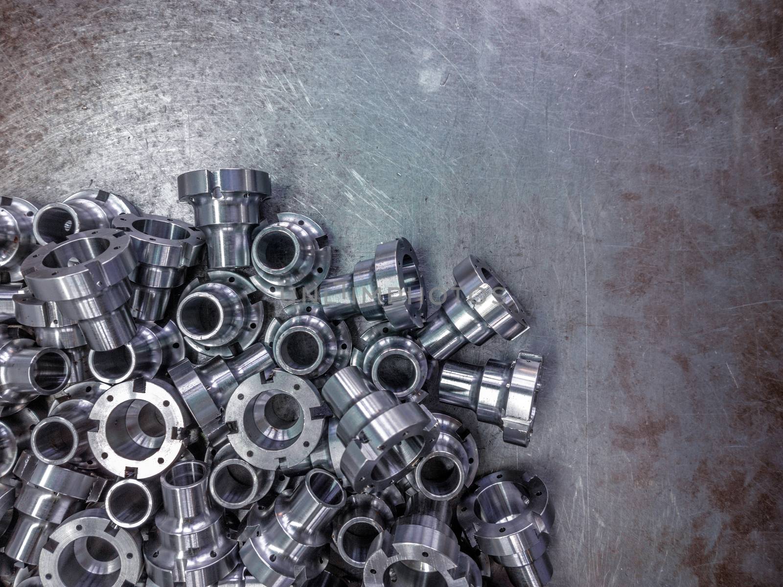 Shiny steel parts after cnc turning, drilling and machining on steel surface selective focus composition background.