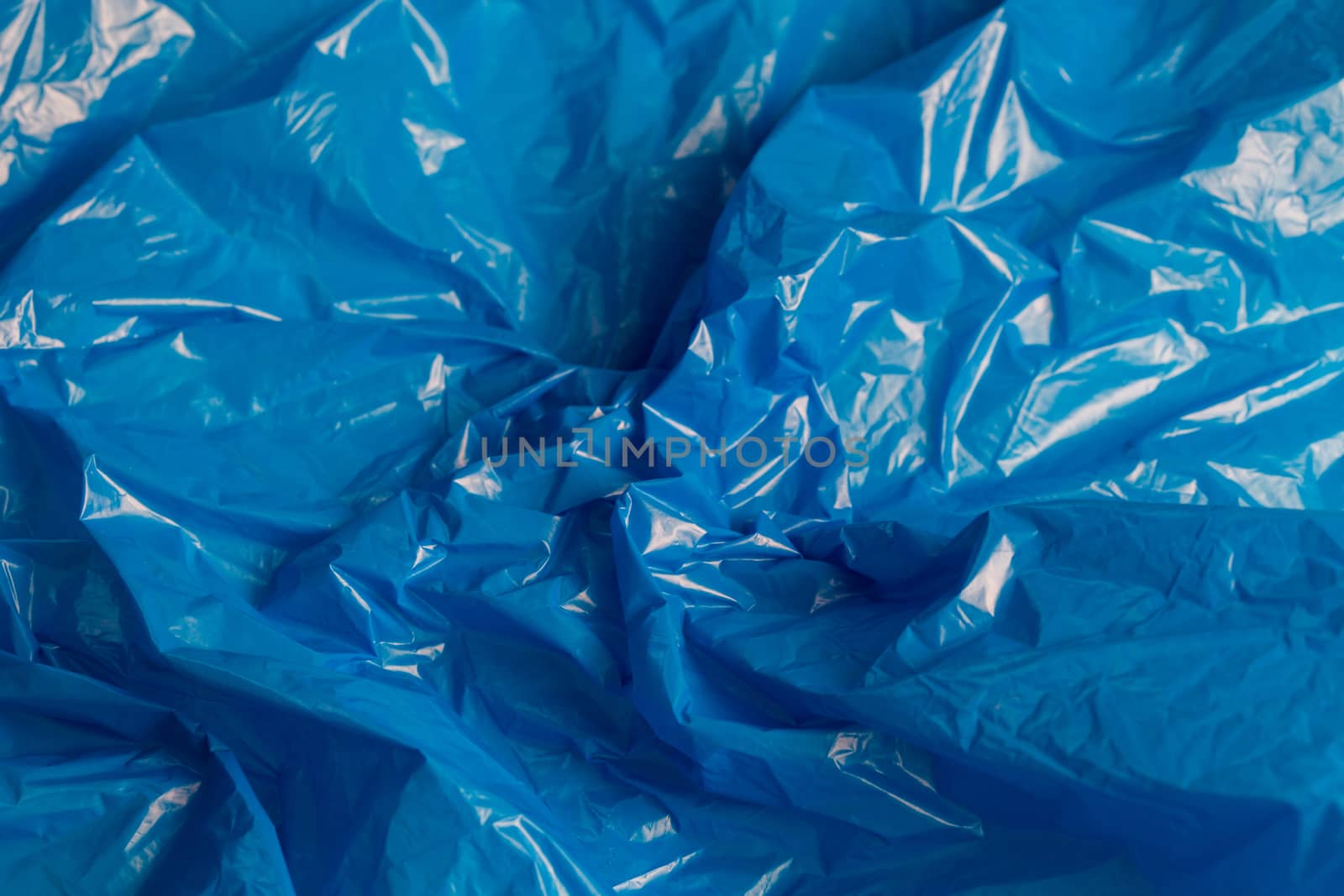 crumpled polyethilene film abstract background with selective focus.