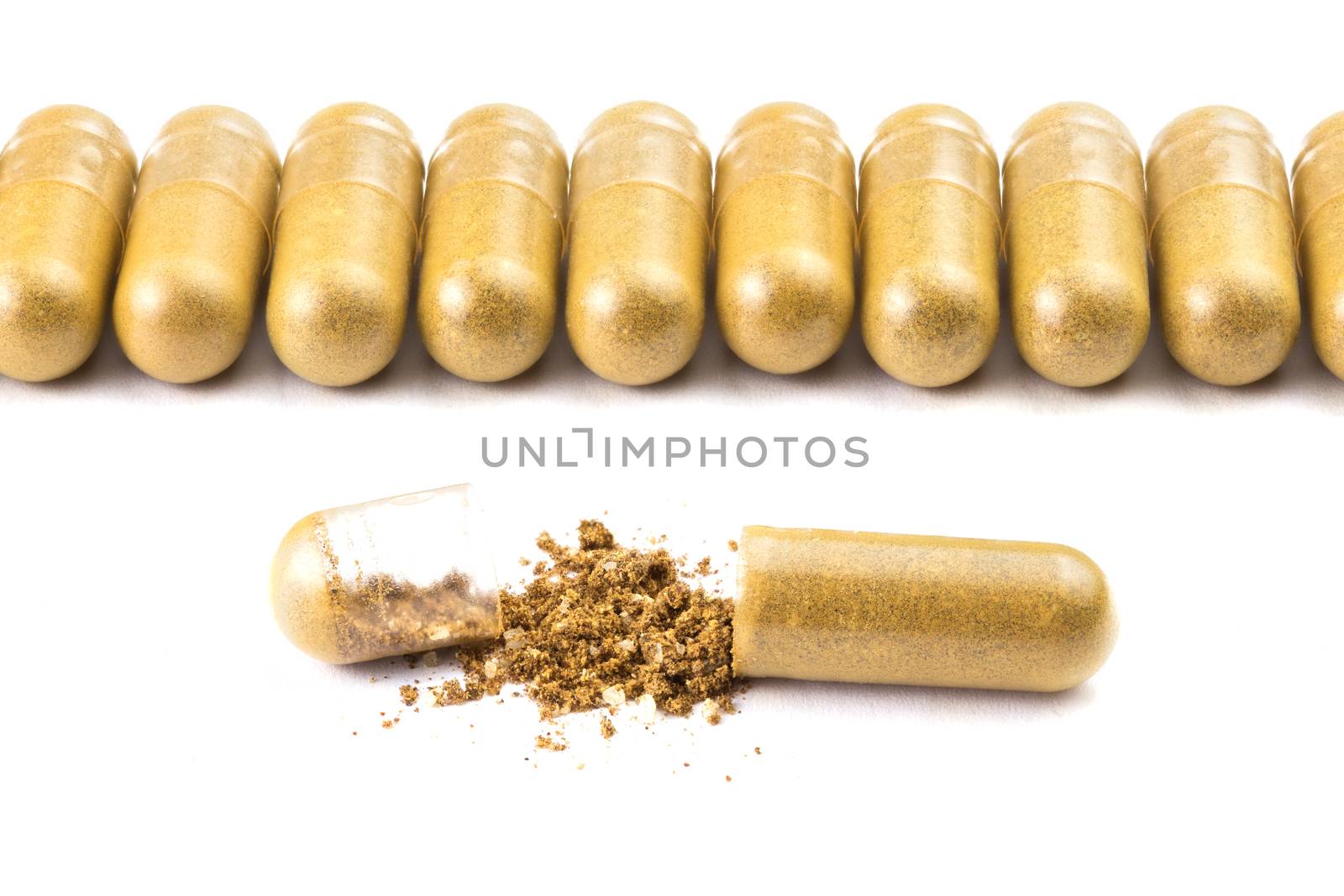 row of orange color organic capsules isolated on white background closeup with one opened.