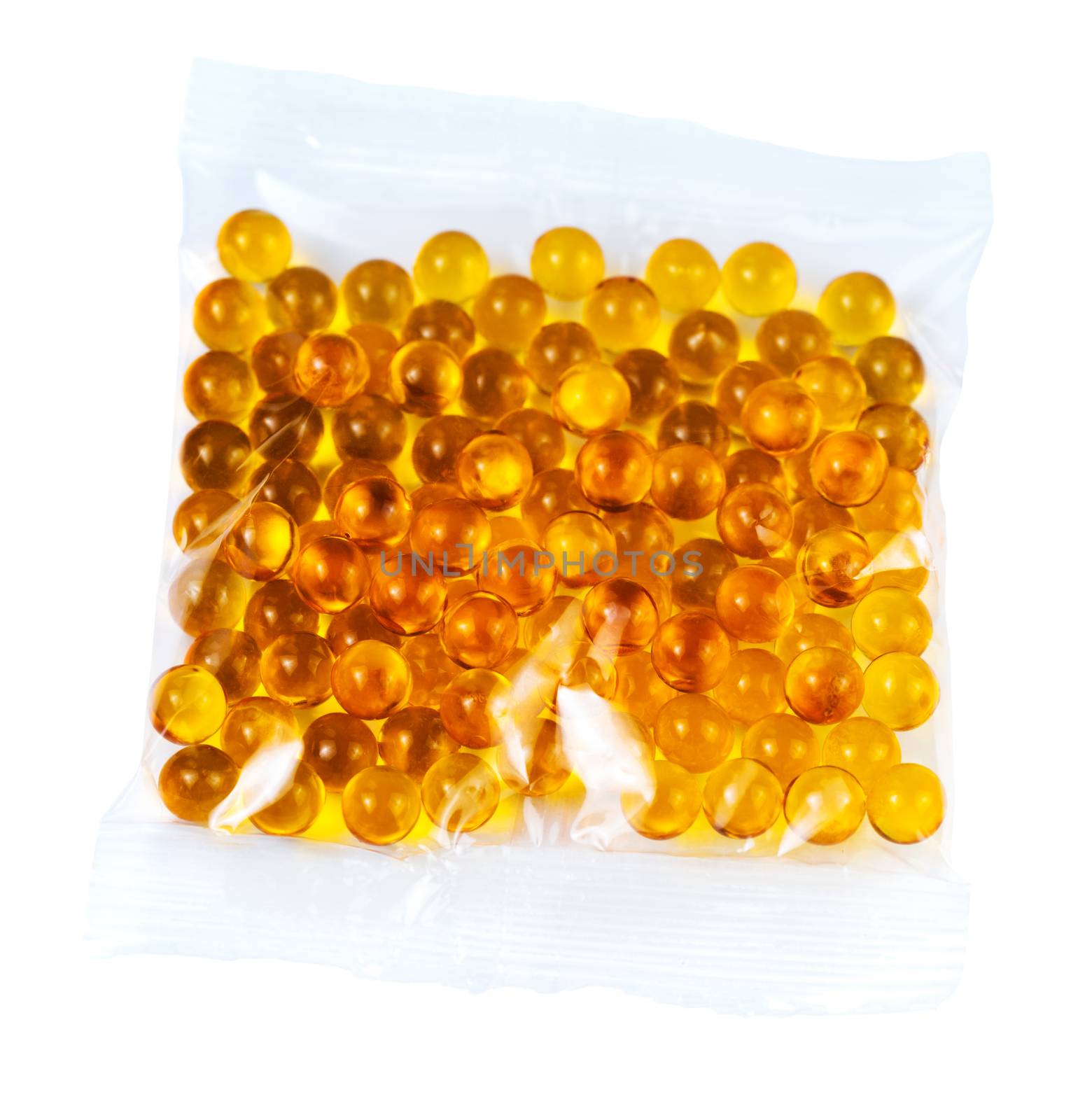 orange spherical ball capsules of fish oil in plastic bag isolated on white background.