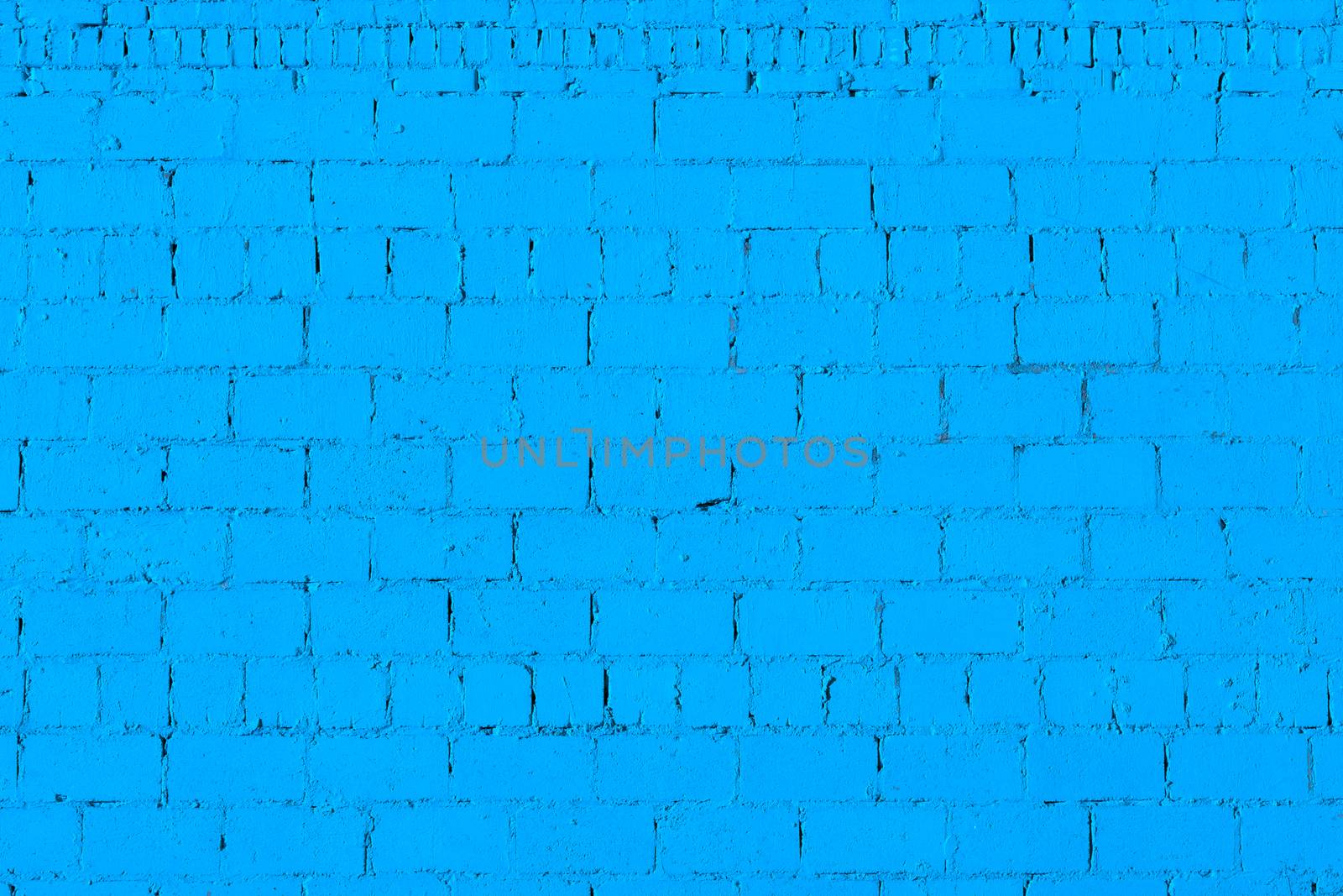 blue plaster rough brick wall texture under direct sunlight