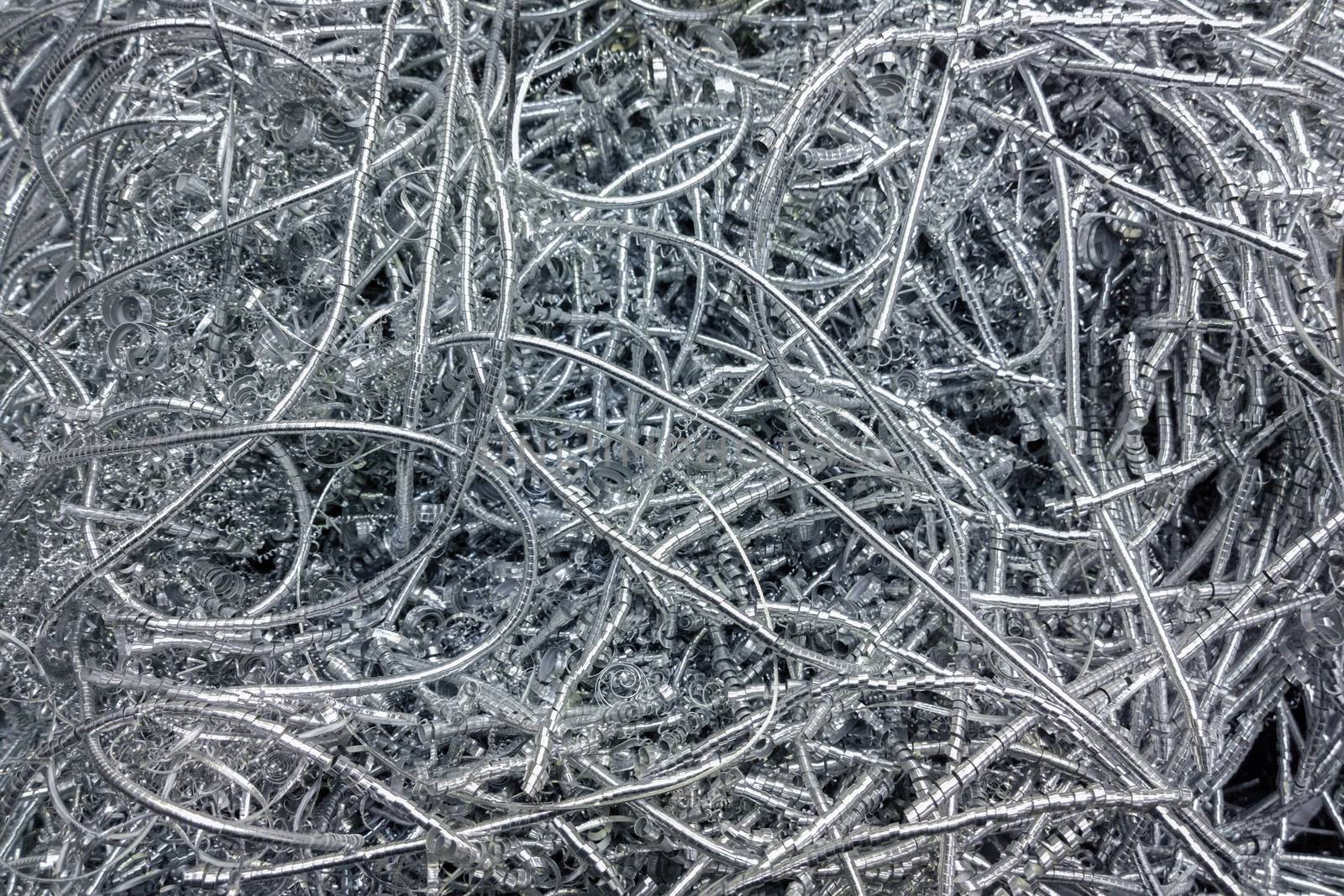 Long curly aluminium chips pattern background with selective focus.