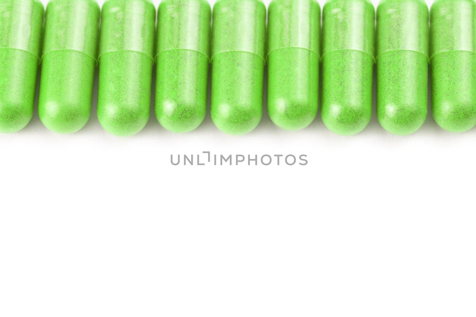 row of ufo green color organic capsules isolated on white background closeup with selective focus.