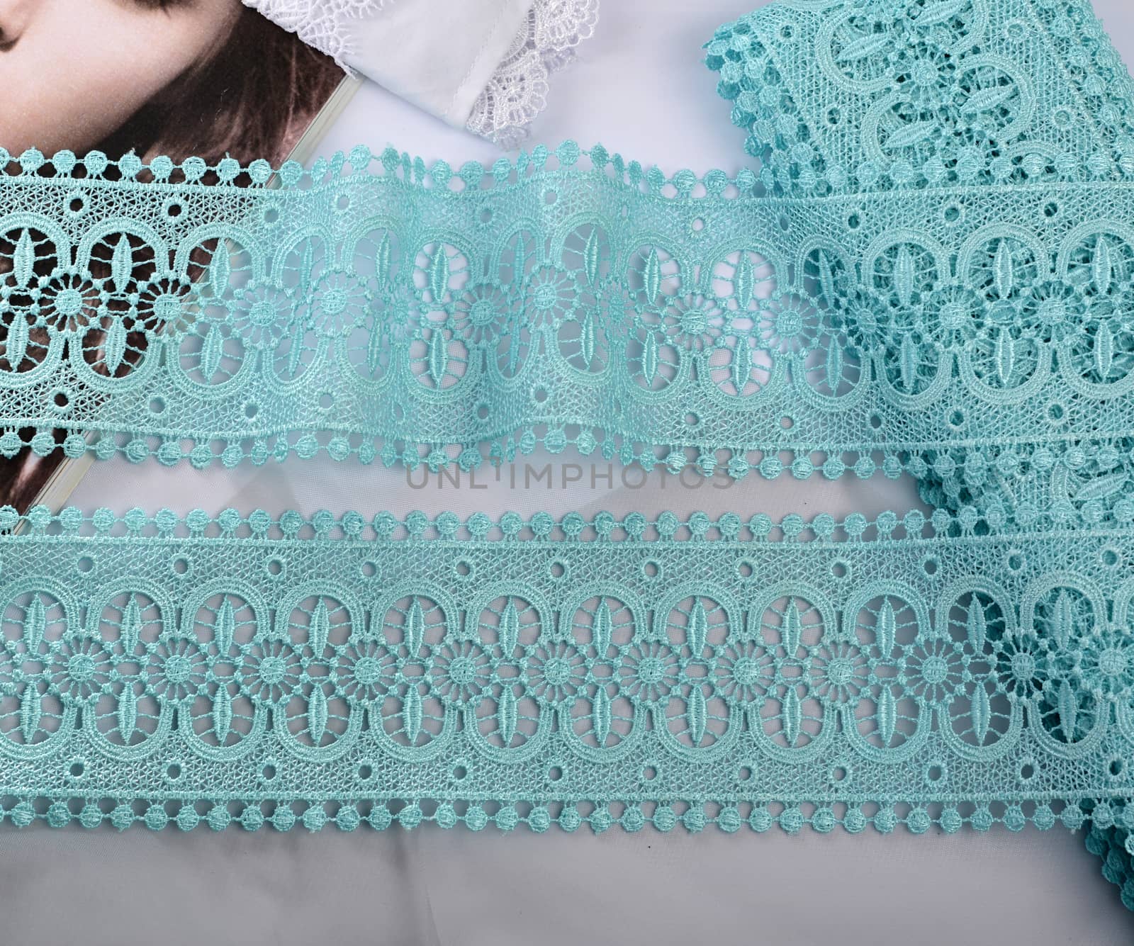 Tapes of blue gentle guipure, beauty silk lace fabric on light background. Elastic material. Using for Atelier and needlework store. Flat lay style