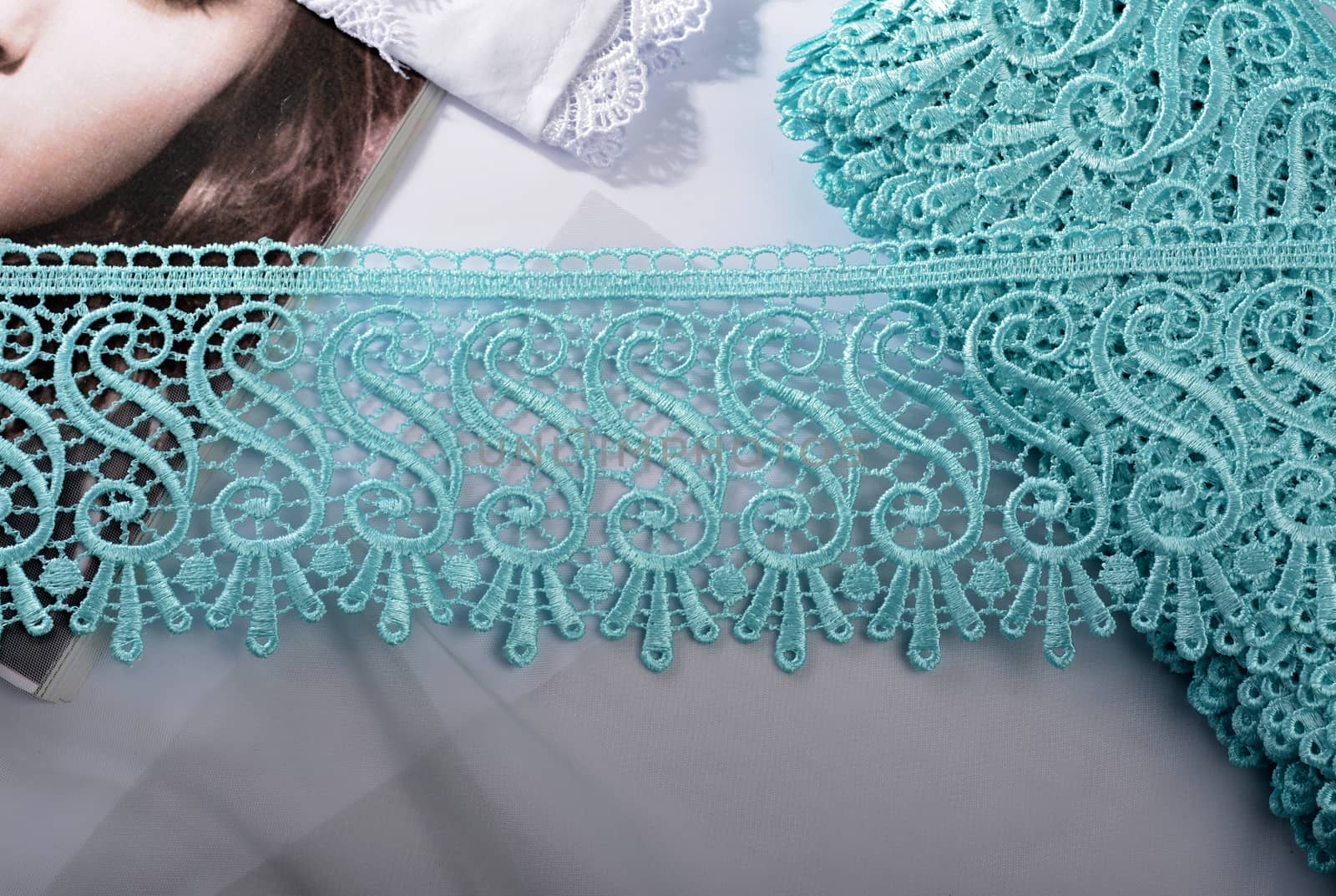 Tapes of blue gentle guipure, beauty silk lace fabric on light background. Elastic material. Using for Atelier and needlework store. Flat lay style