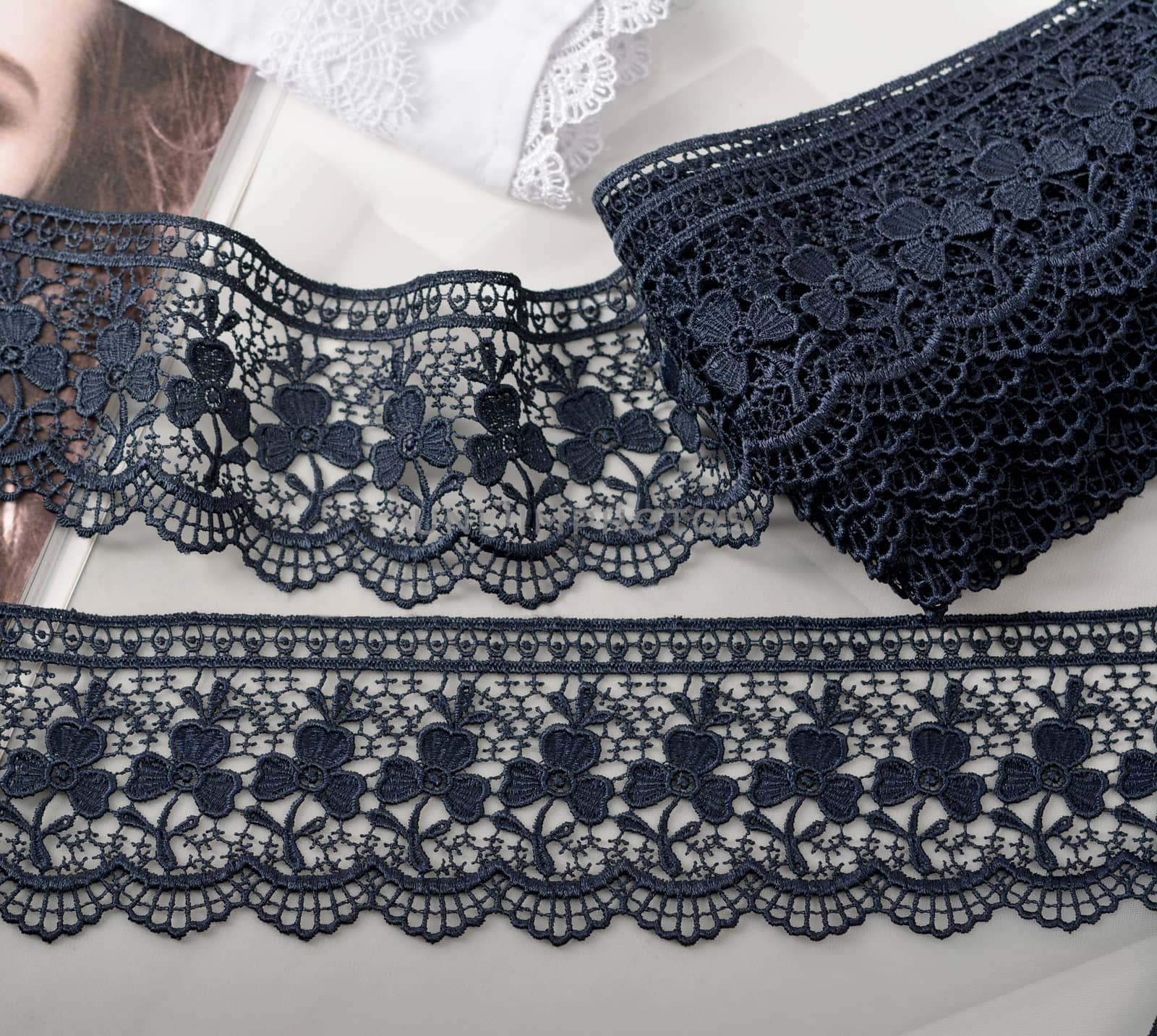 Tapes of blue gentle guipure, beauty silk lace fabric on light background. Elastic material. Using for Atelier and needlework store. Flat lay style