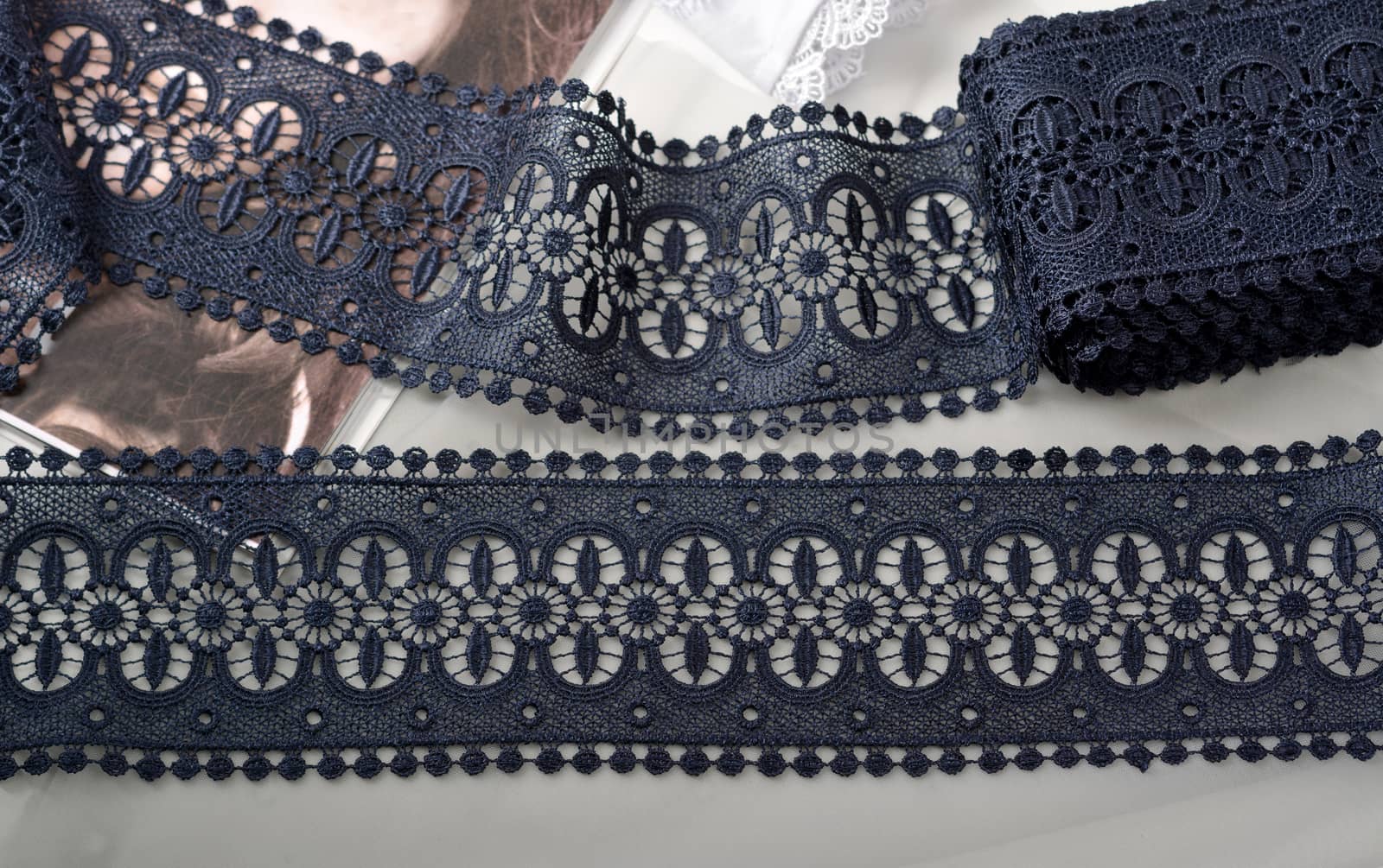 Tapes of blue gentle guipure, beauty silk lace fabric on light background. Elastic material. Using for Atelier and needlework store. Flat lay style
